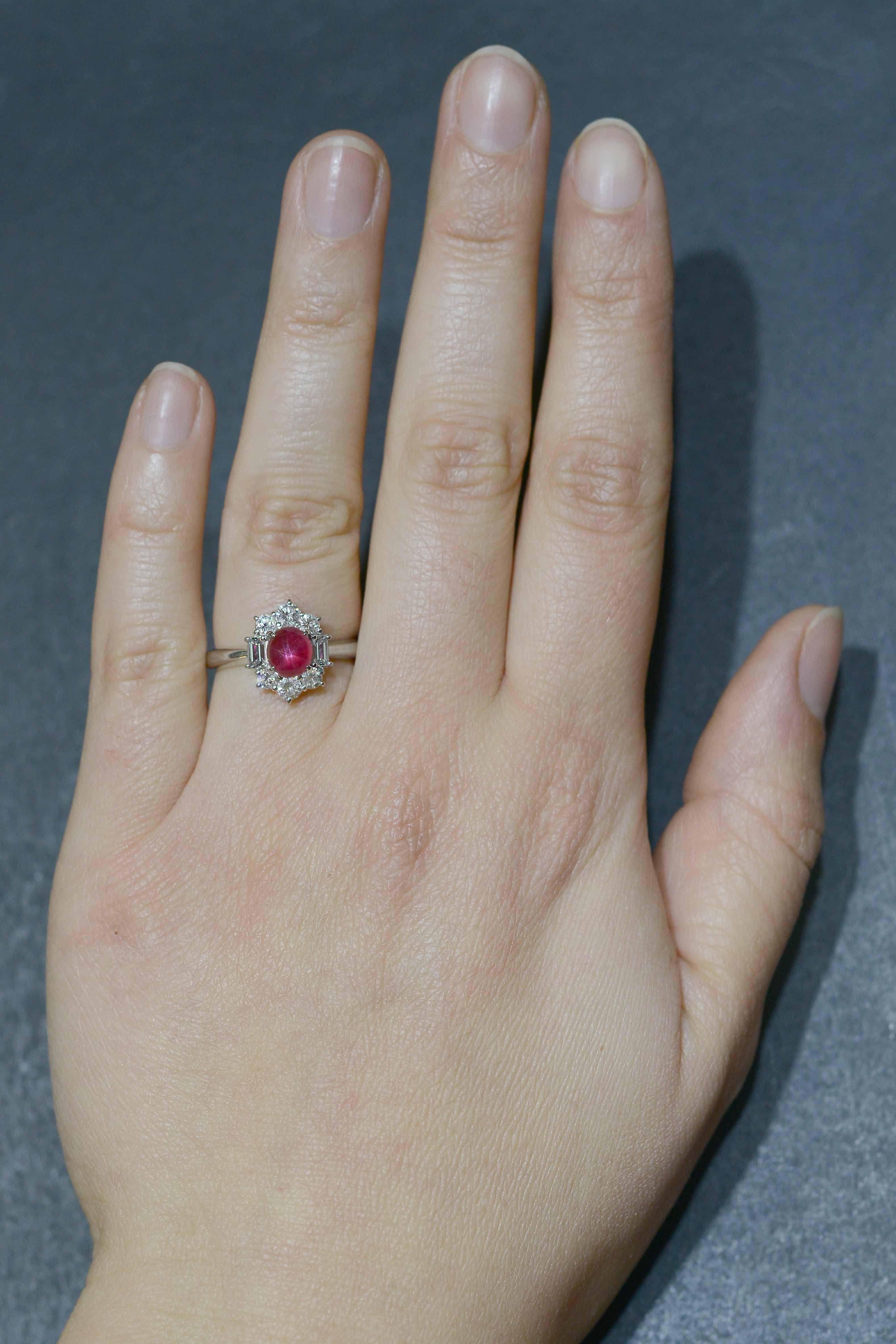 A stellar mid-century ring featuring an exceptional star ruby with a bright center and dramatic, vivid legs. This anomalous gemstone is surrounded by a tiara of glimmering, colorless diamonds in a ballerina-style setting flaunting a variety of round