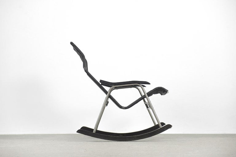 This folding modern rocking chair was designed by Takeshi Nii during the 1950s. It has a black leather upholstered and aluminum frame on wooden sleds. This folding model is easy to storage and transport. It is a brother of famous NY Chair. Designer