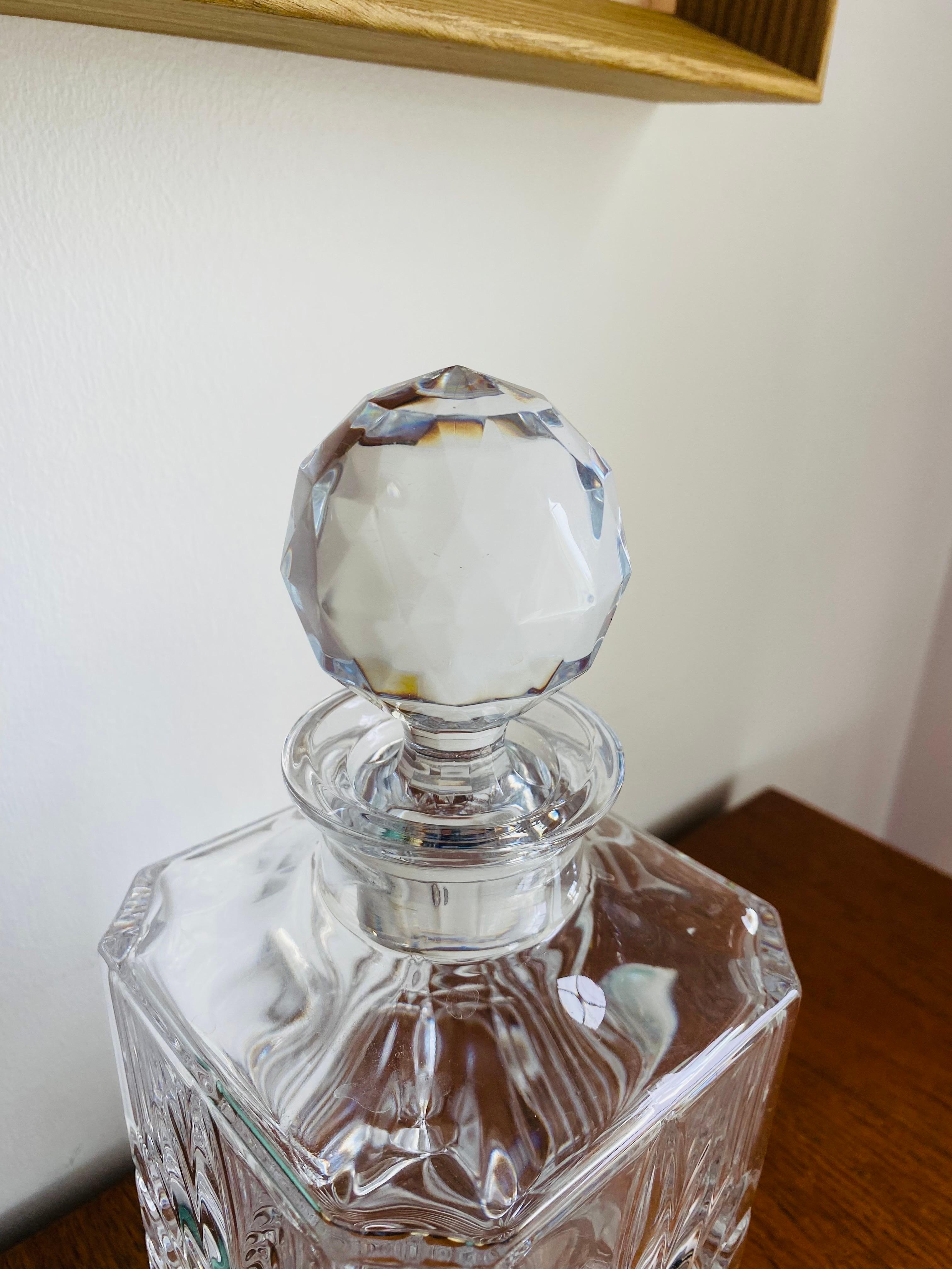 Beautiful 1960s Mid Century Modern elegant crystal glass decanter from France. This beautiful piece exudes style and glamour. Presenting itself as a crystal column with a facetted stopper, this decanter is perfectly balanced with its fan-like design