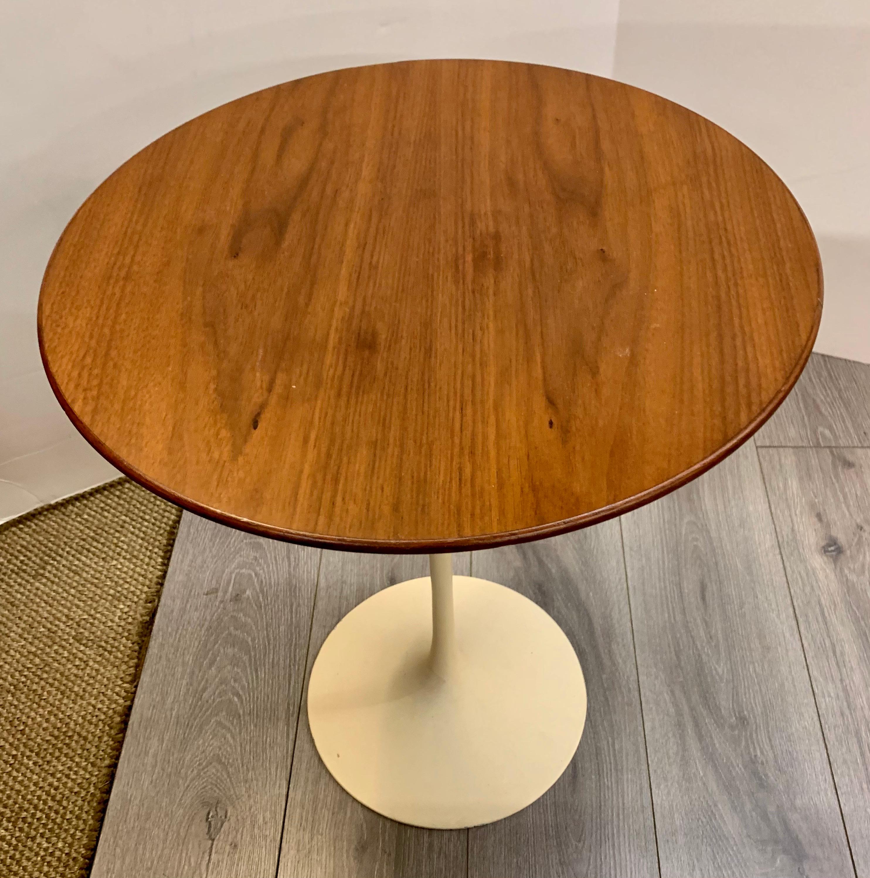 Classic tulip side table designed by Eero Saarinen and manufactured by Knoll. This table has a 20 inch diameter walnut top and white metal base.