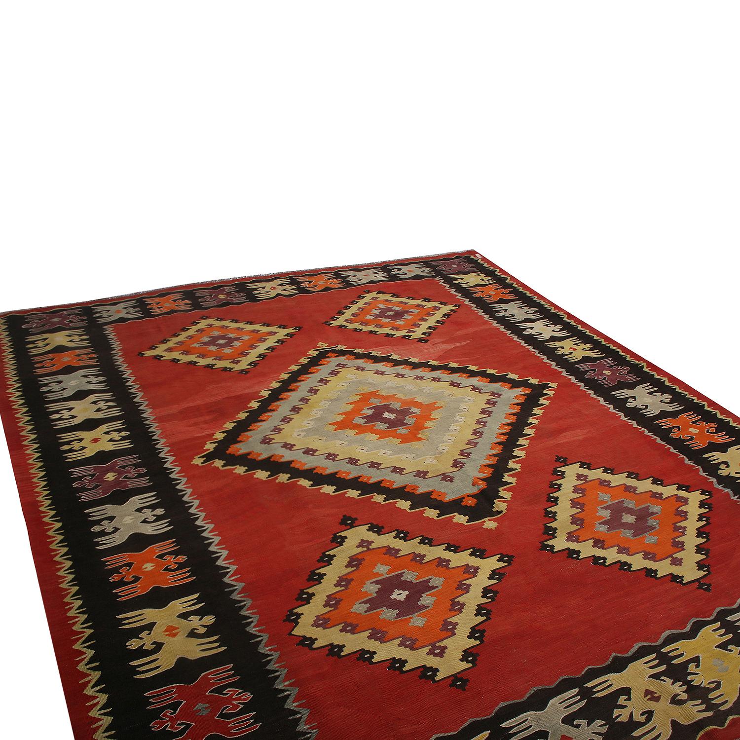 Handwoven in Turkey originating between 1950-1960, this vintage midcentury 8’ x 10’ wool Kilim hails from the seaside town of Sarkoy (Sarköy), hosting an uncommon black border and a similarly rare variation of the tribal diamond pattern highlighting
