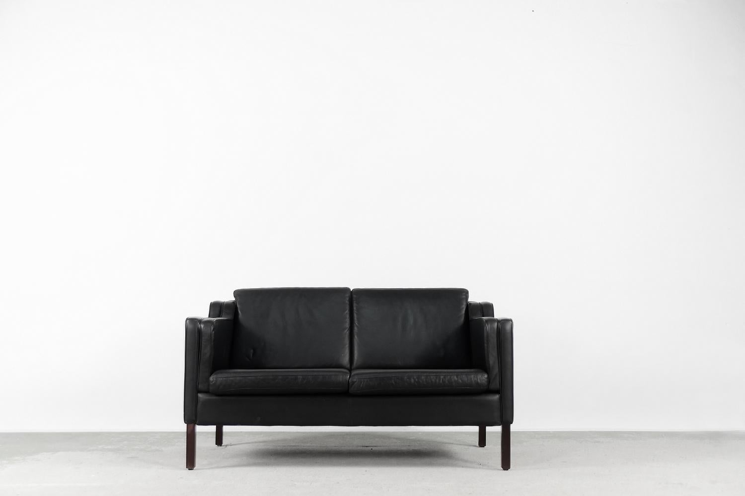 This elegant, two-seater sofa was produced by the Danish Stouby manufacture in the second half of the 20th century. This design was made according to the model 2212 designed by Børge Mogensen for Fredericia. Stouby is a company that has been an