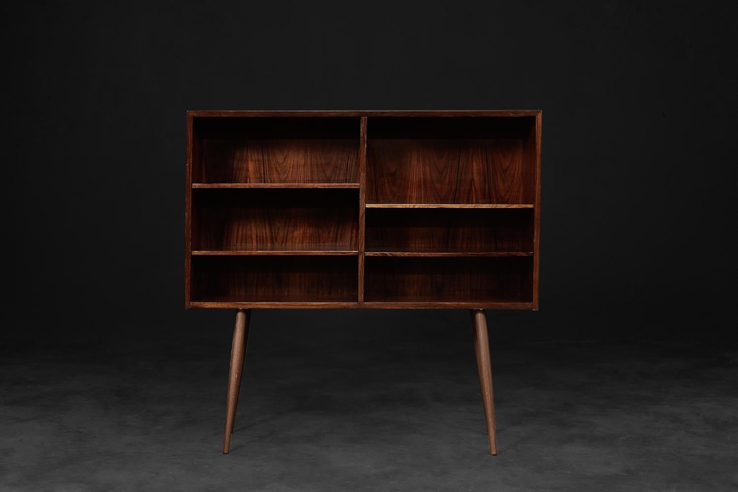 This modernist cabinet was designed by Gunni Omann for the Danish manufacturer Omann Jun Møbelfabrik during the 1960s. It is made of high-quality rosewood. Its structure is very strong, with expressive graining, which gives furniture made of this