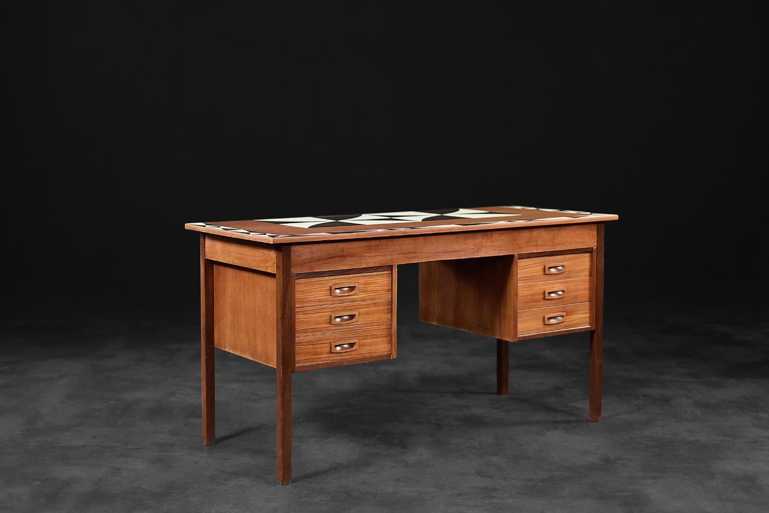 This classic desk was produced in Denmark during the 1960s. It is made of teak in a warm shade of brown. Teak wood is very durable. The high oil content means that virtually no water seeps into it. The desk has six drawers, three on each side. The