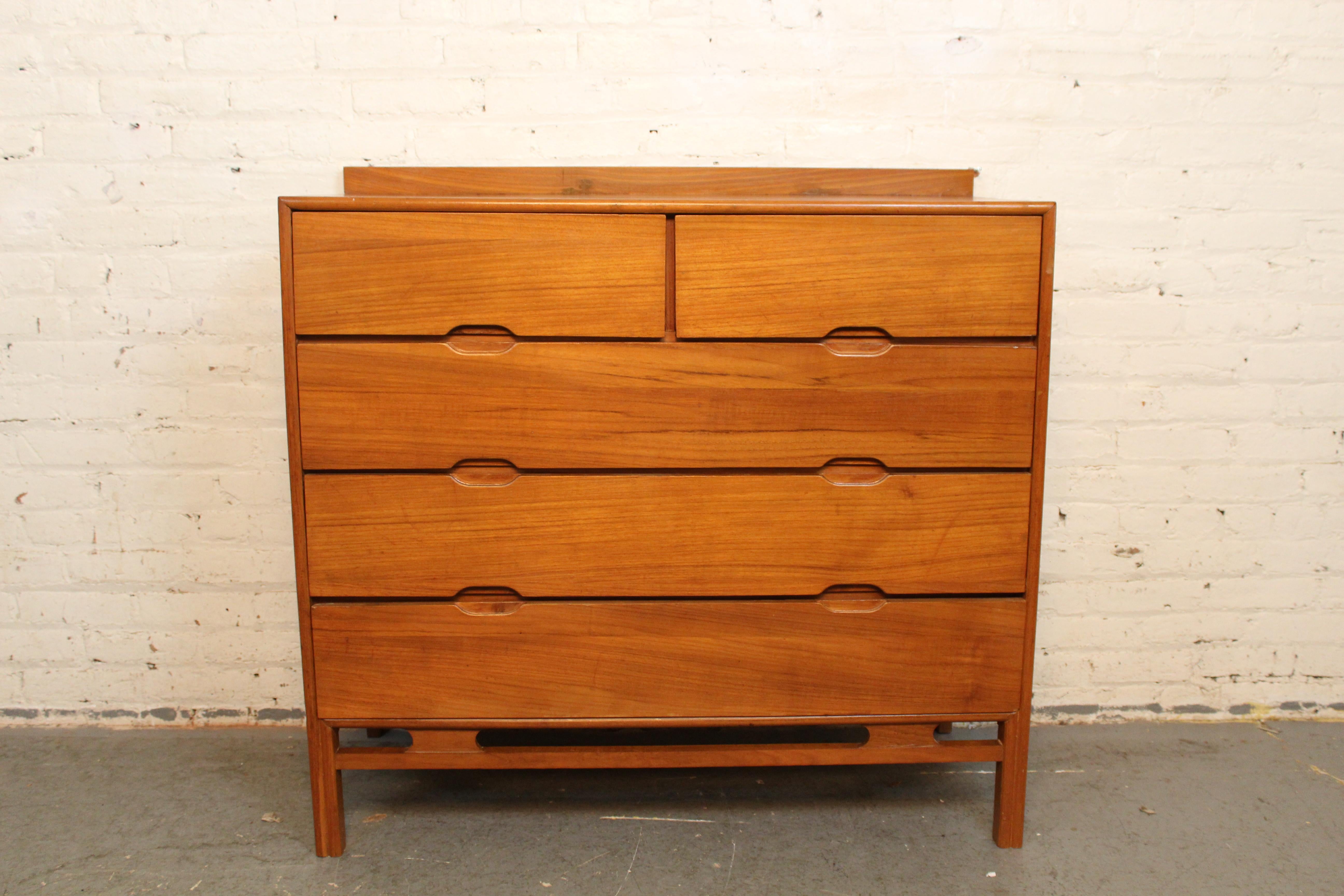 Don't miss out on classic Scandinavian modern design for your home! This petite mid-century teak chest of drawers has Danish style in spades- with carved oval drawer pulls, hourglass details, and bold geometric lines. Five total drawers offer plenty