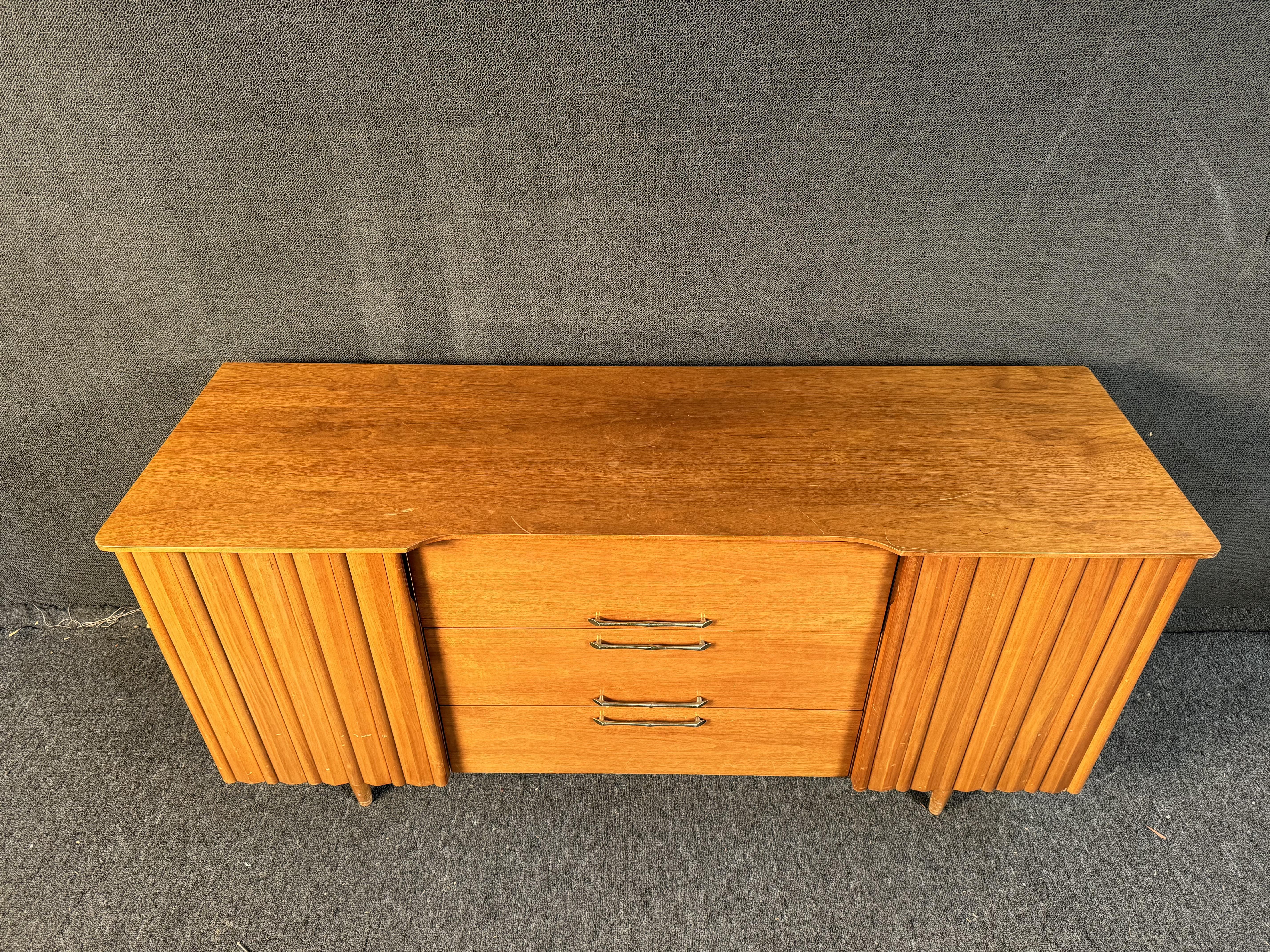 Buffet vintage discret de United Furniture. Avec 4 tiroirs et des étagères pour tous vos besoins de rangement dans la salle à manger. Veuillez confirmer la localisation avec le concessionnaire (NY ou NJ)