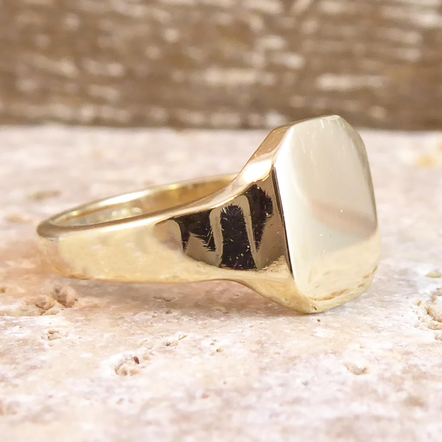 A vintage signet ring from the mid-20th Century with a square, cut-cornered top plain polished, without crest or initials.  The top measures approx. 0.32 x 0.38 inches to a D shaped cross section band approx. 0.13