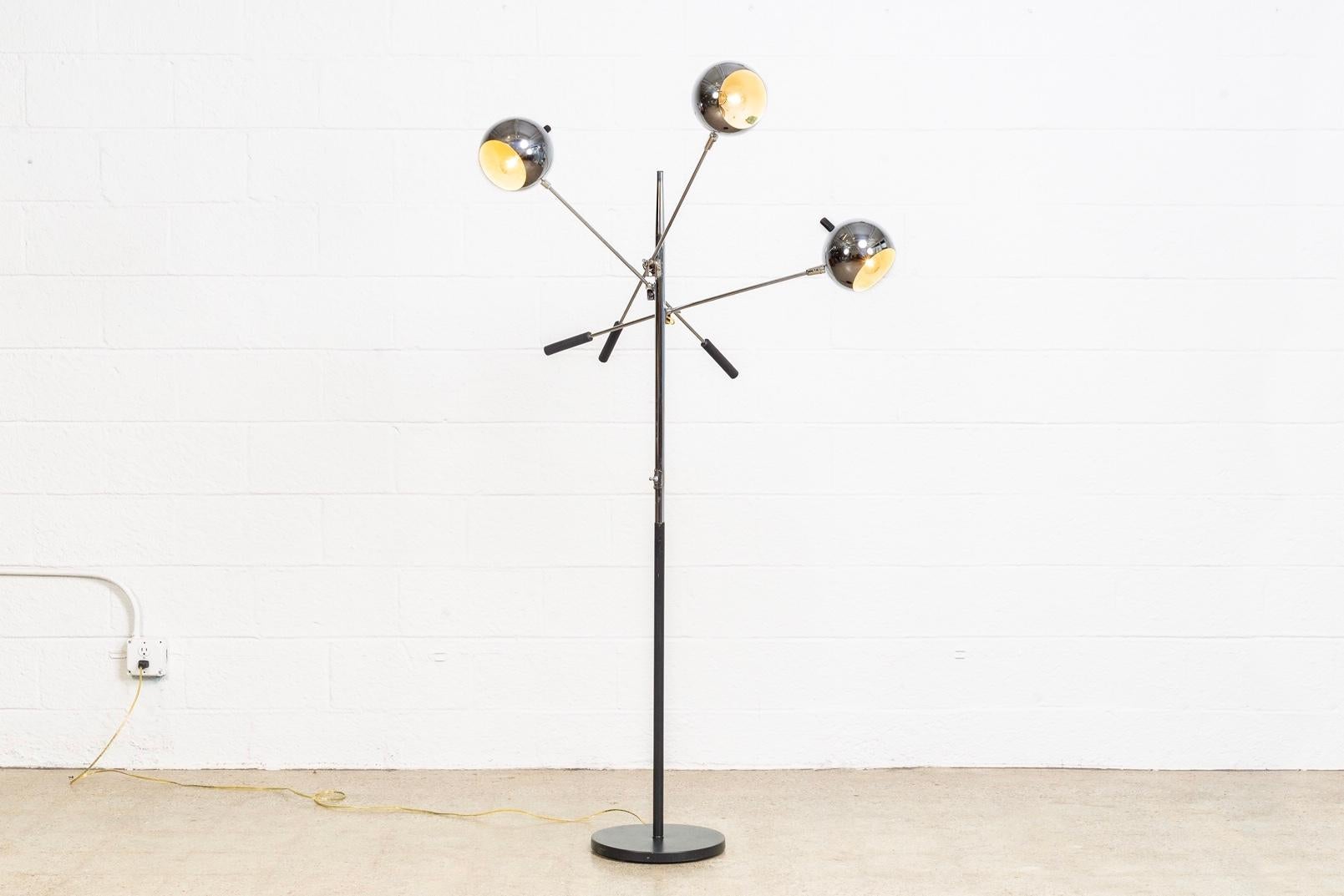 This vintage Mid-Century Modern Triennale floor lamp attributed to Robert Sonneman is circa 1970. It features three chromed orb globe lights on adjustable, counter-balanced lever arms. Lamp arms adjust up and down and orb lampshades pivot both up
