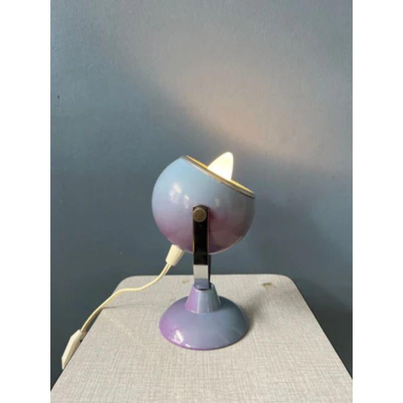 A small space age eyeball table lamp in purplish colour. The eyeball shade can be directed in different directions. The lamp is made out of metal. The lamp requires one E14 lightbulb and currently has an EU plug.

Dimensions: 
ø Shades: 9