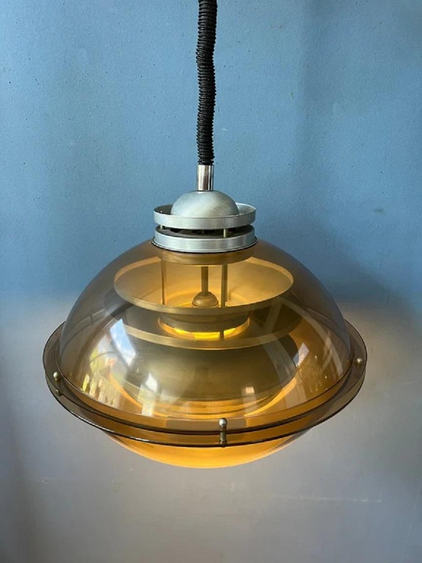 A very special space age pendant light by the Dutch brand Herda. The lamps consists of an brown/copper coloured outer shade and an aluminum inner shade. The lamp requires one E27 lightbulb and currently has an EU-plug.

Dimensions: 
ø: 35 cm
Height
