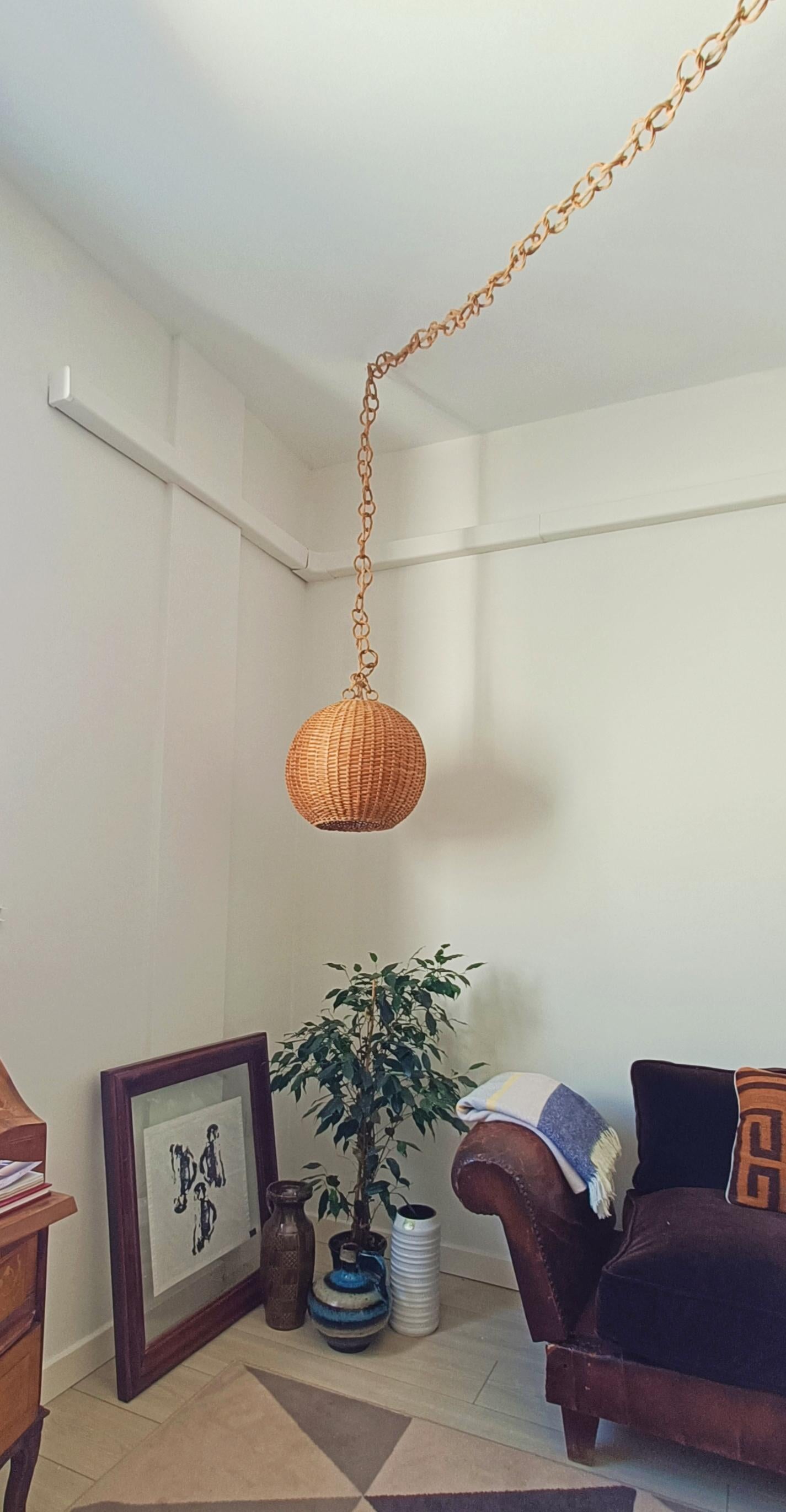 Superbe lampe suspendue en osier en forme de ballon, Vintage Mid-Century Modern, faite à la main en Espagne vers les années 1950.

La chaîne de suspension est également faite d'anneaux d'osier tressés à la main et est très longue : 270cm plus