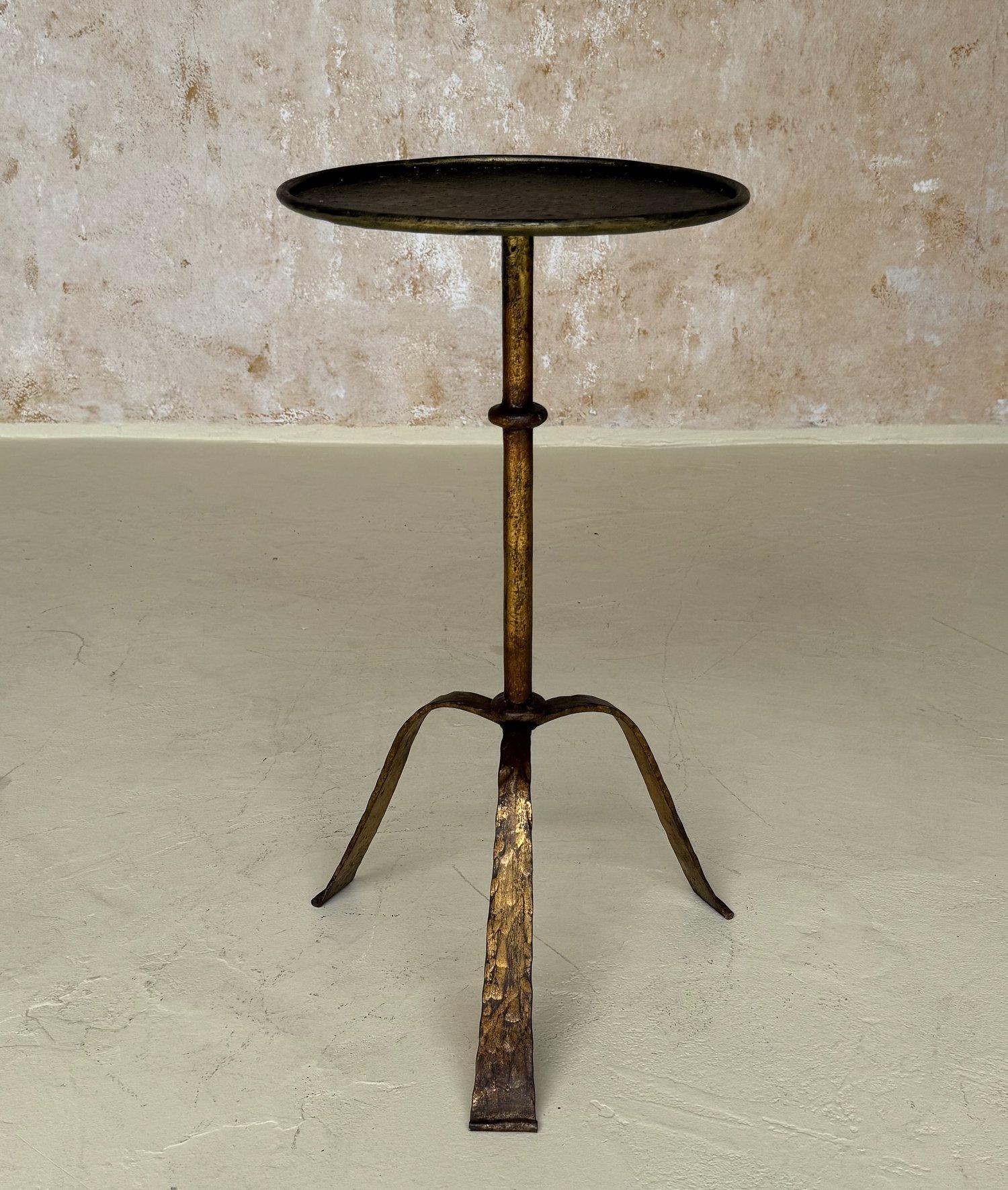 Cette table d'appoint en fer espagnole du milieu du siècle dernier présente une tige centrale avec un anneau central décoratif monté sur un trépied gracieusement arqué reposant sur des pieds martelés. La patine dorée d'origine, appliquée à la main,