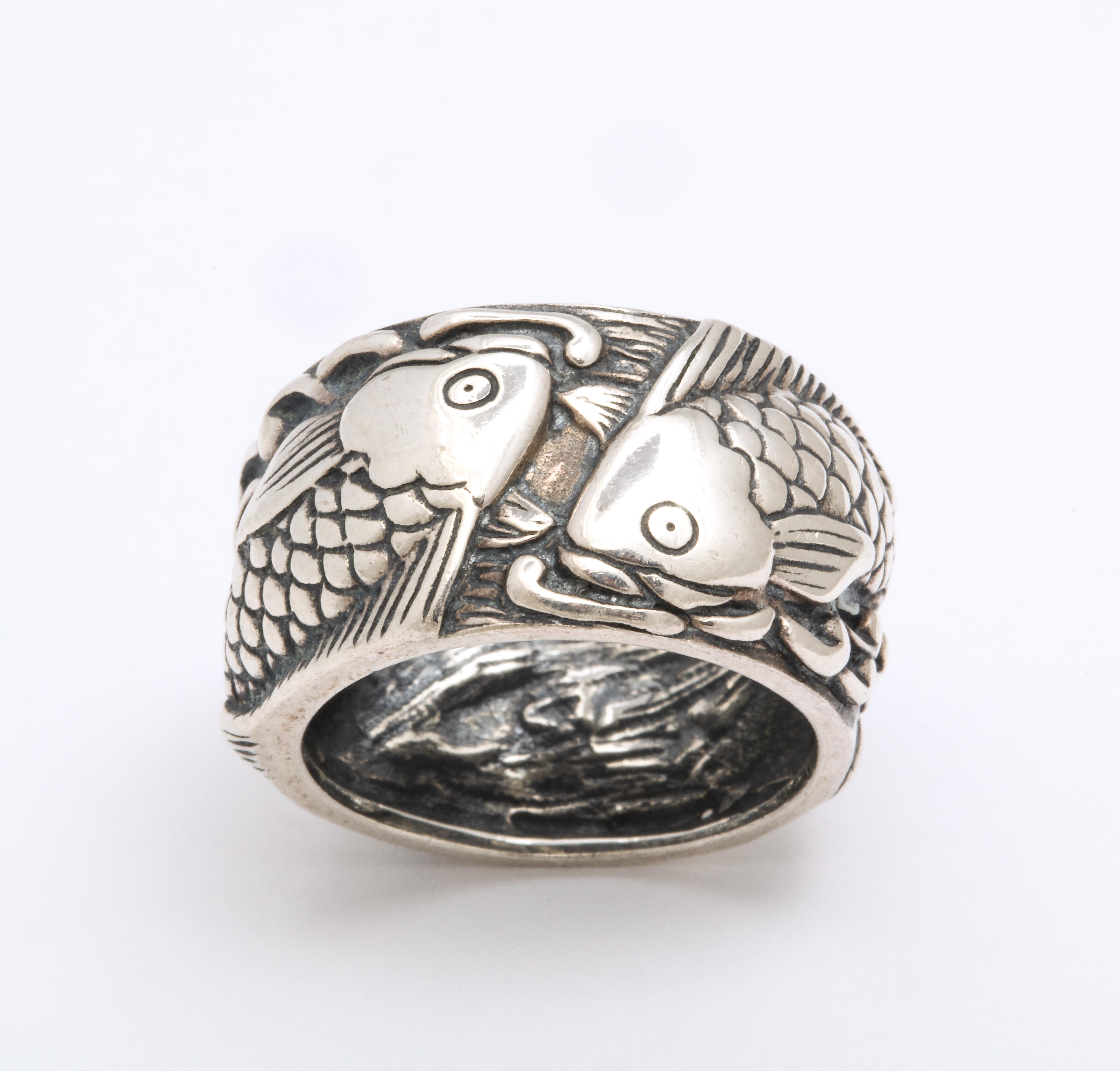 This is a mid century silver Pisces ring that is crisply engraved with so much detail and whimsy that I can't help but smile One does bot have to be a Pisces to enjoy the fun of this ring. Two fish splash their way through the waves. The splashes