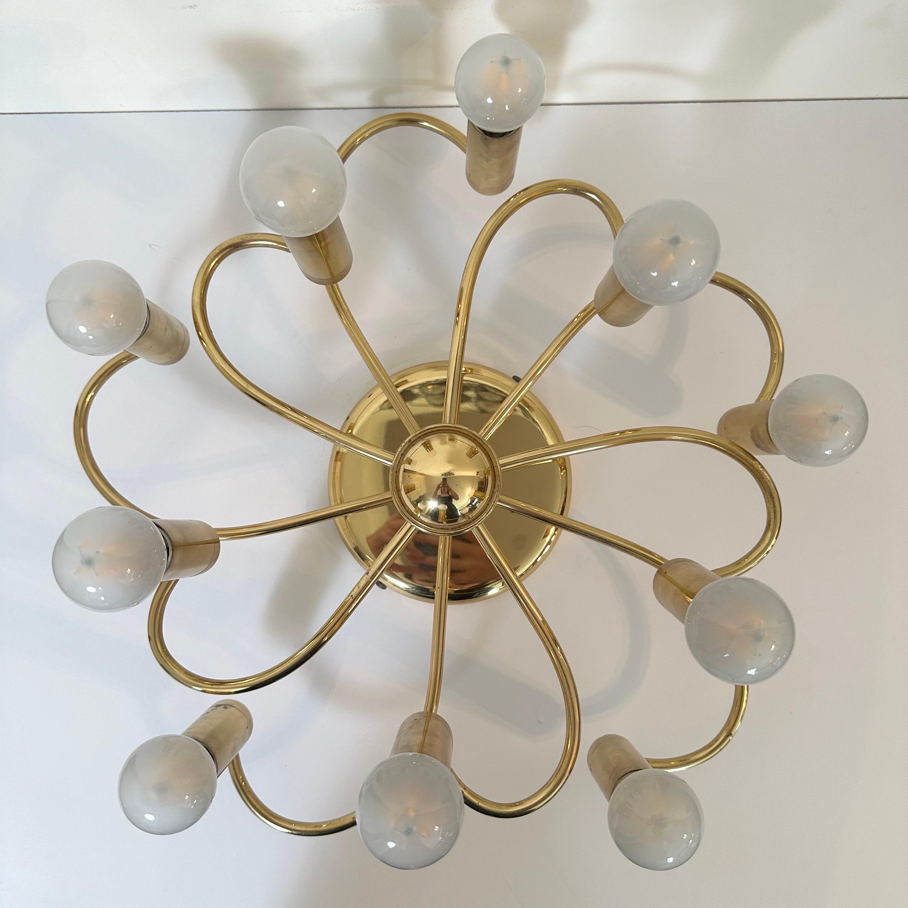 Vintage brass flush mount with 10 lights. Each spiraling, curved arm supports one light, with arms at varying levels, for an overall impression of a spinning motion. Made by Honsel, Germany in the style of Italian creators like Gaetano Sciolari.