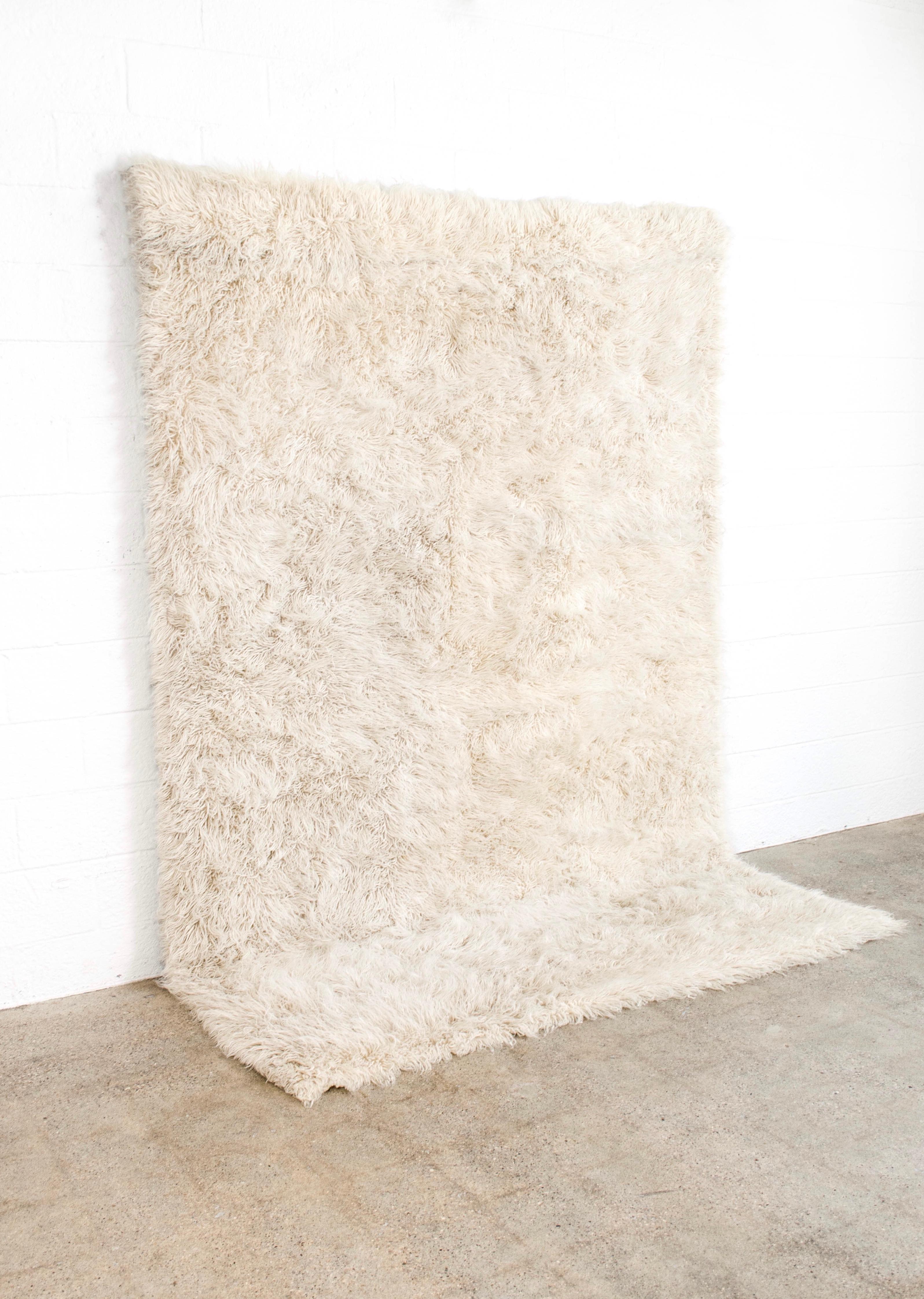 This beautiful large vintage Rya wool shag rug was made in Sweden, circa 1960. Handwoven from 100% un-dyed wool, the rug has a soft and luxurious thick shaggy pile. The clean, minimalist design of this natural ivory carpet makes it the perfect