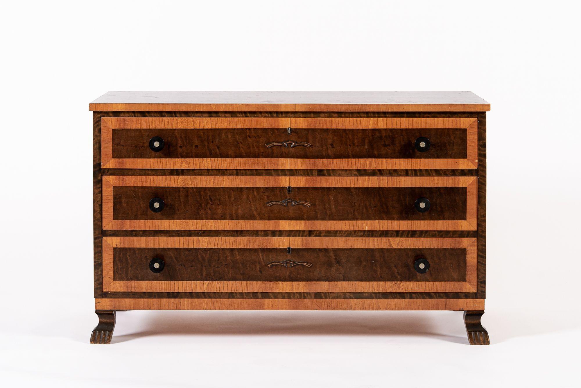 This vintage mid century Swedish modern three-drawer wooden dresser or low chest with carved stylized claw feet was made in Sweden circa 1940. This unique piece elegantly combines modern and traditional elements and features a beautiful two-toned
