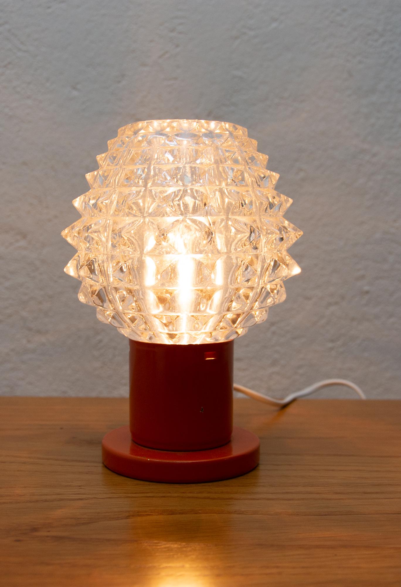 Vintage midcentury table lamp from the 1960s. It was produced by Kamenicky Šenov. The lamp is fully functional. Very well preserved condition. Cut glass, brass stand. One E-14 Bulb. 250 V.