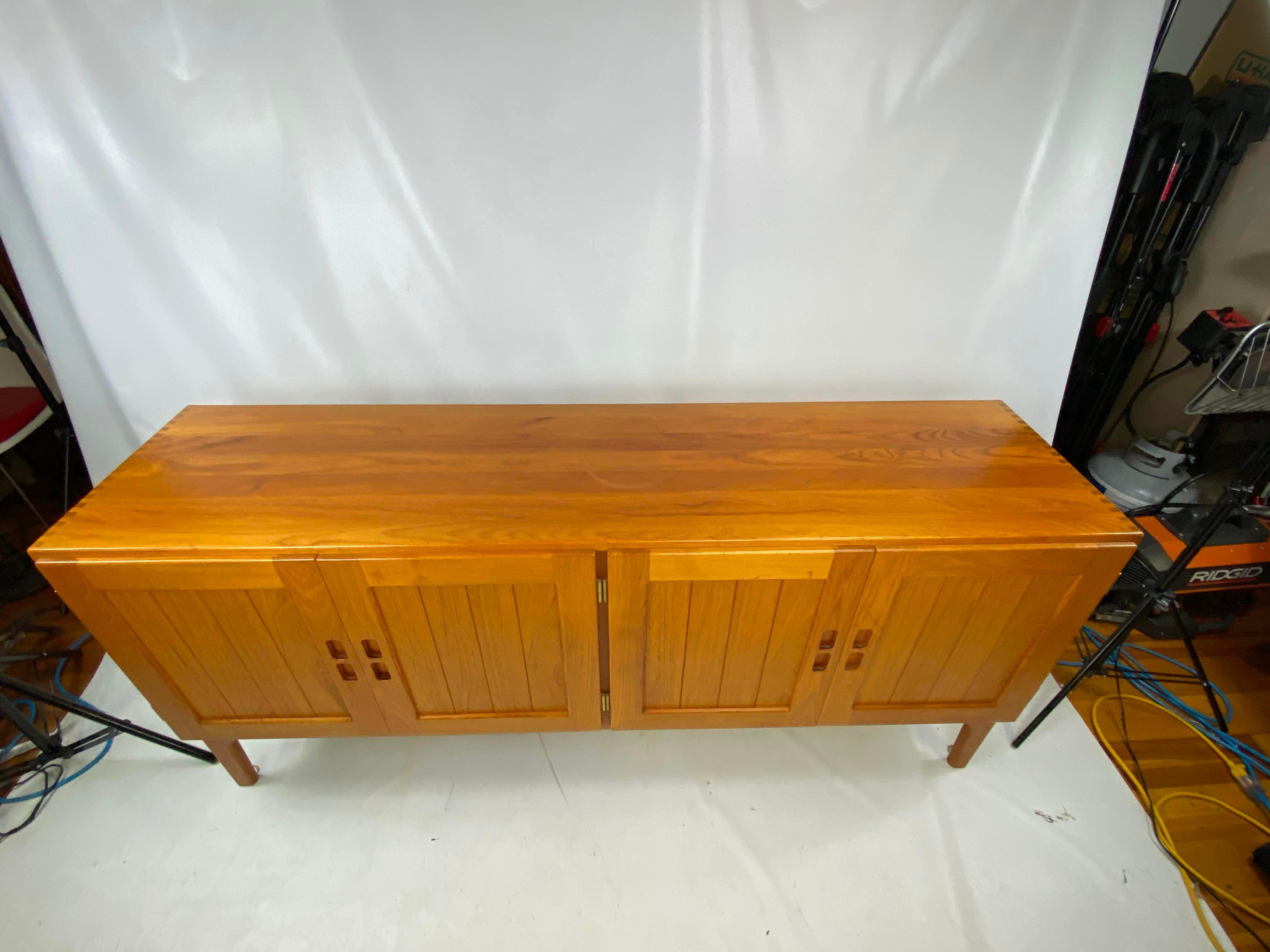 This is a very nice clean line midcentury Danish credenza. Credenza is solid teak very well made. Marked on bottom Danish. Nice dovetailed corners.