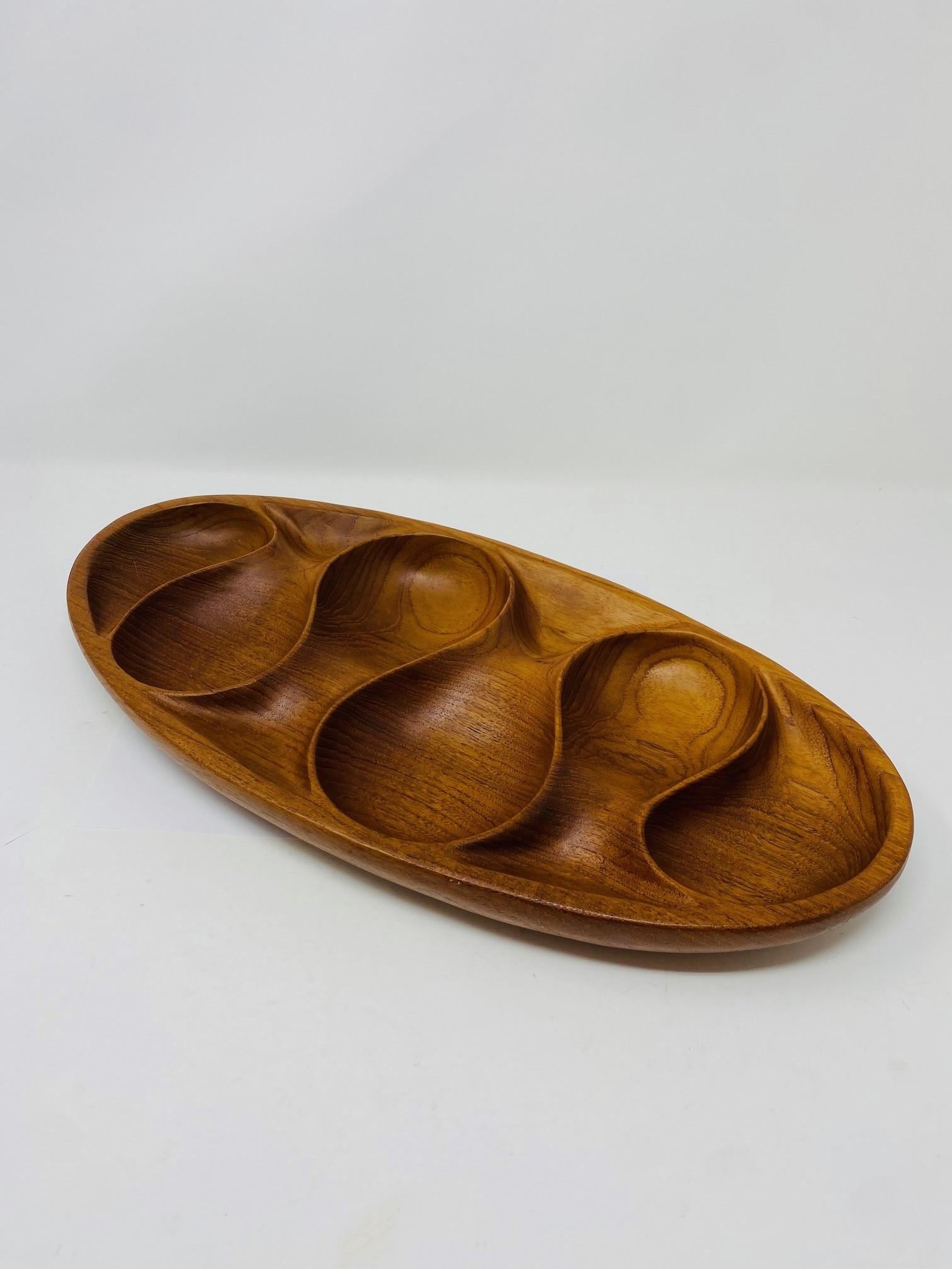 A beautiful and classic Mid-Century object that is ever timeless.  This beautiful bowl/tray created in teak is constructed with 6 carved components that transcend utility to make it sculptural.  An incredible example of Danish hand crafted design.