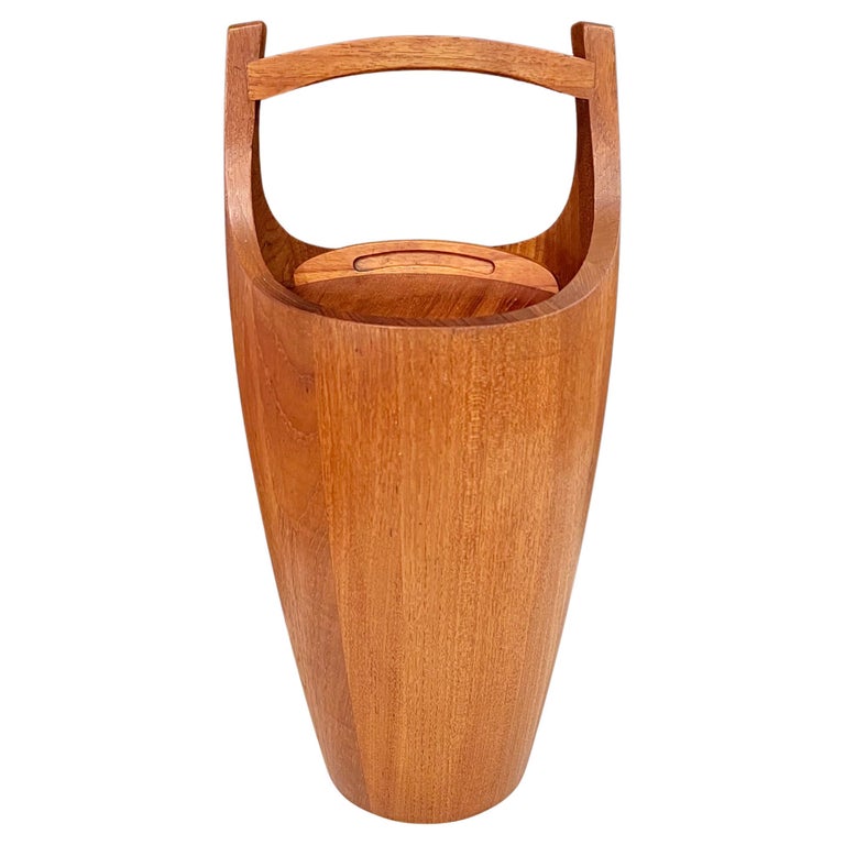 Vintage Danish Mid-Century Modern teak “Congo” ice bucket designed by Jens Harald Quistgaard for Dansk, circa 1950. With orange liner, this piece is truly a sculpture. This piece presents a beautifully sculpted caramel-hued teak. This early edition