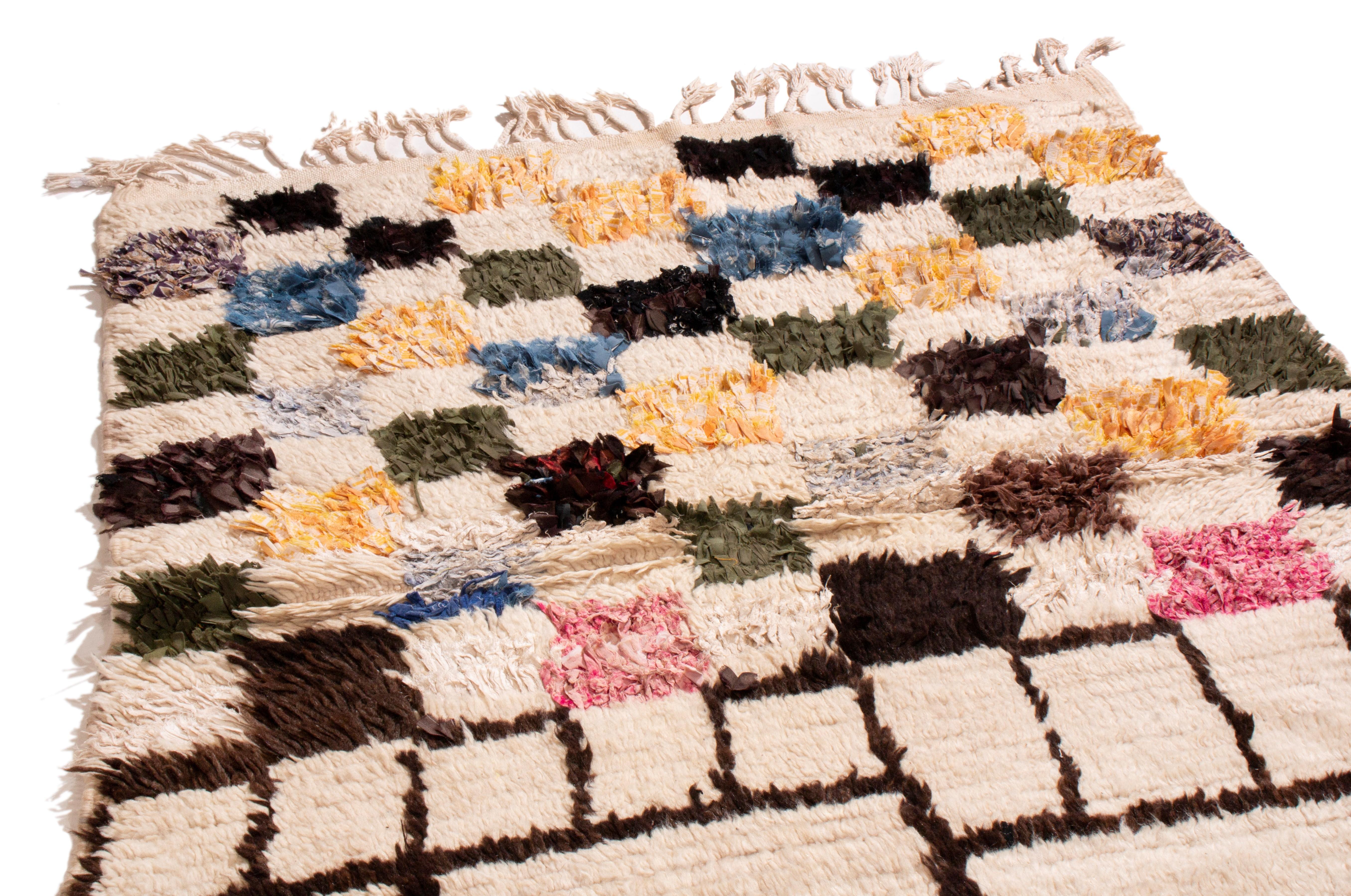 Originating from Morocco in the 1950s, this vintage mid-century Moroccan Berber rug is hand knotted in high quality wool with a rare employment of symmetrical fringes and sharp geometrics. While many Berber pieces of this era favor wilder colors