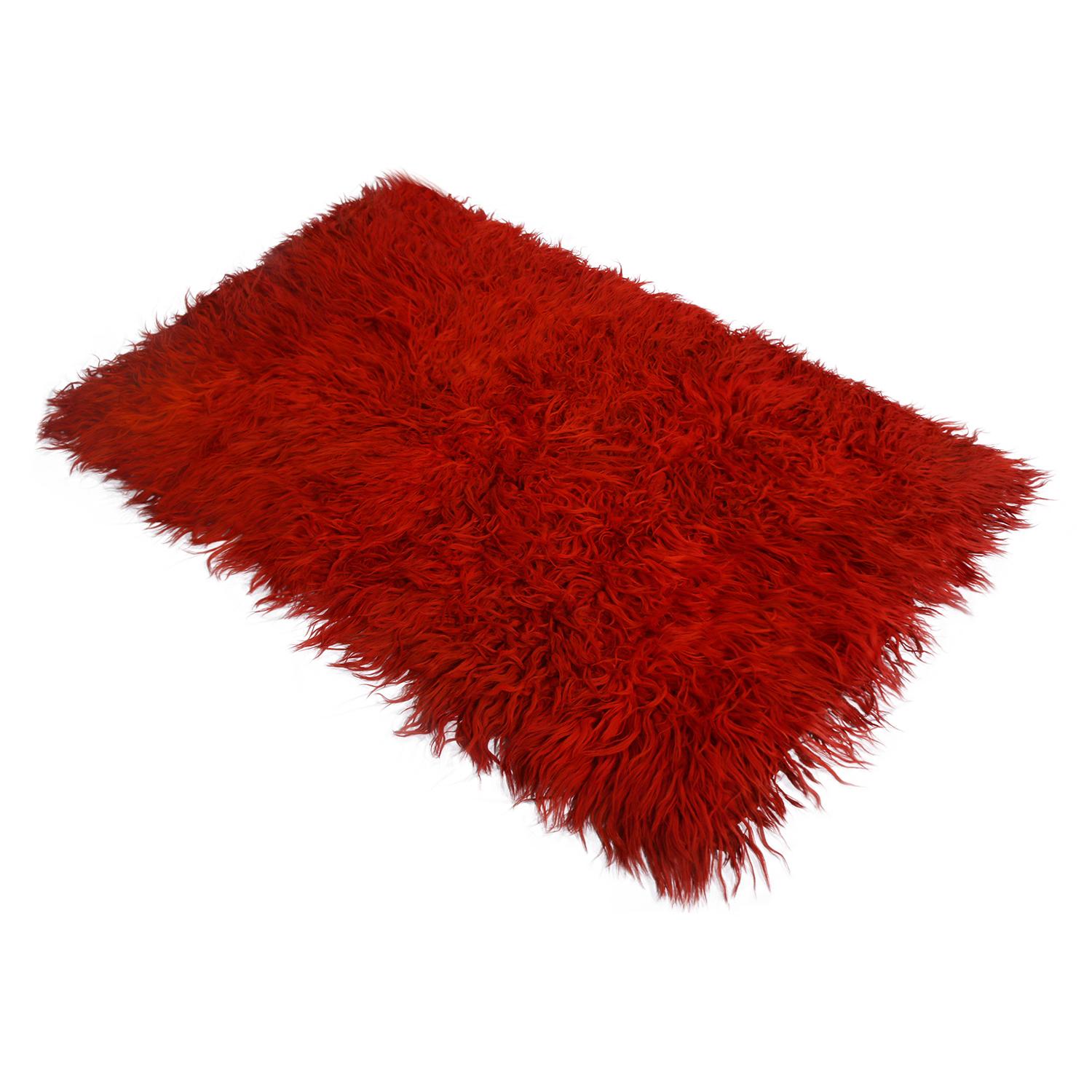 Hand knotted in Turkey originating between 1950-1960, this vintage midcentury Tulu rug offers a distinguished shag pile height with an inviting, plush texture, complemented by the rich, radiant crimson red colorway as well as the versatile size of