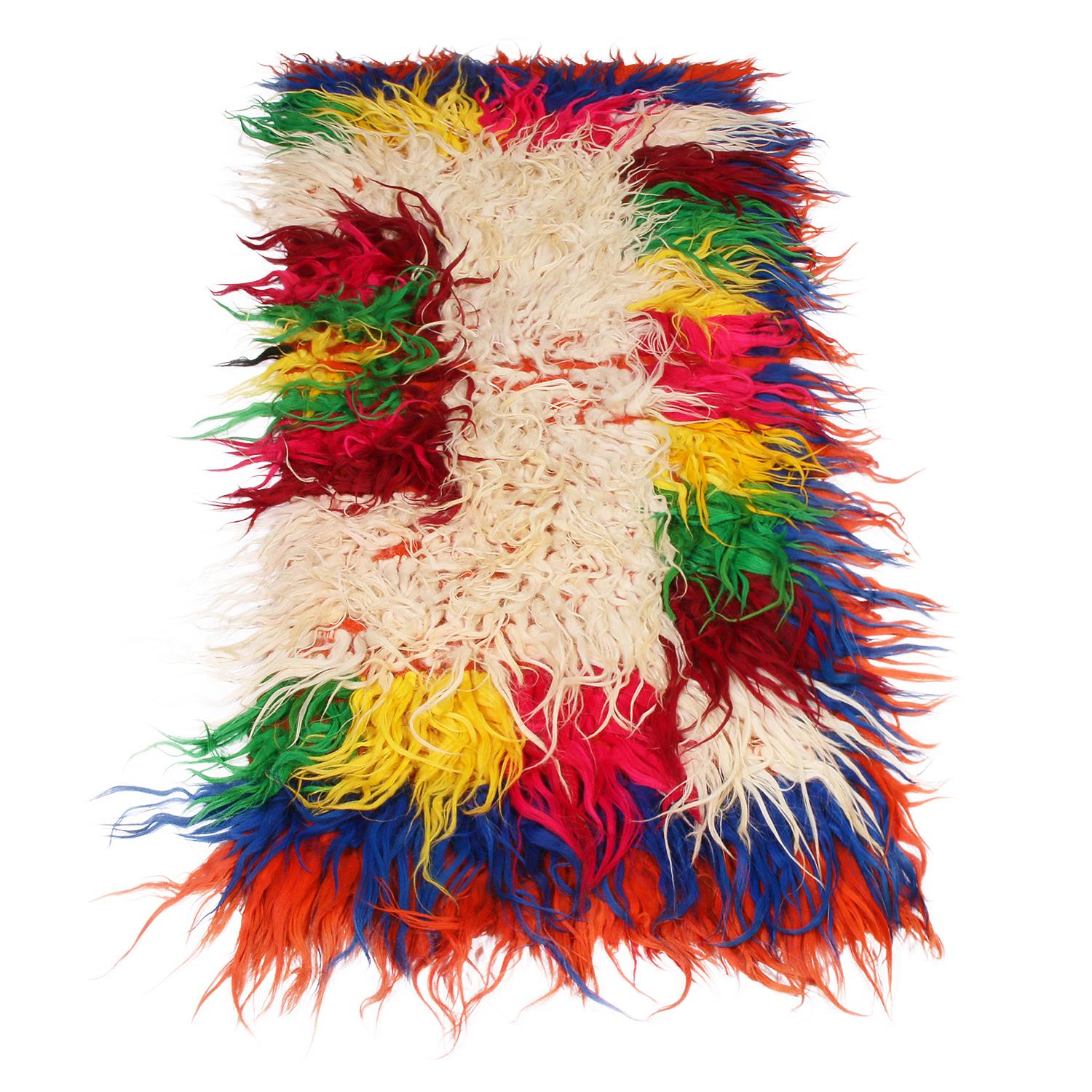 Hand knotted in Turkey originating between 1950-1960, this vintage midcentury Tulu rug enjoys the Classic shag wool pile texture its family is known for in a unique, vibrant array of red, green, yellow, pink, blue, off-white, and orange hues for a