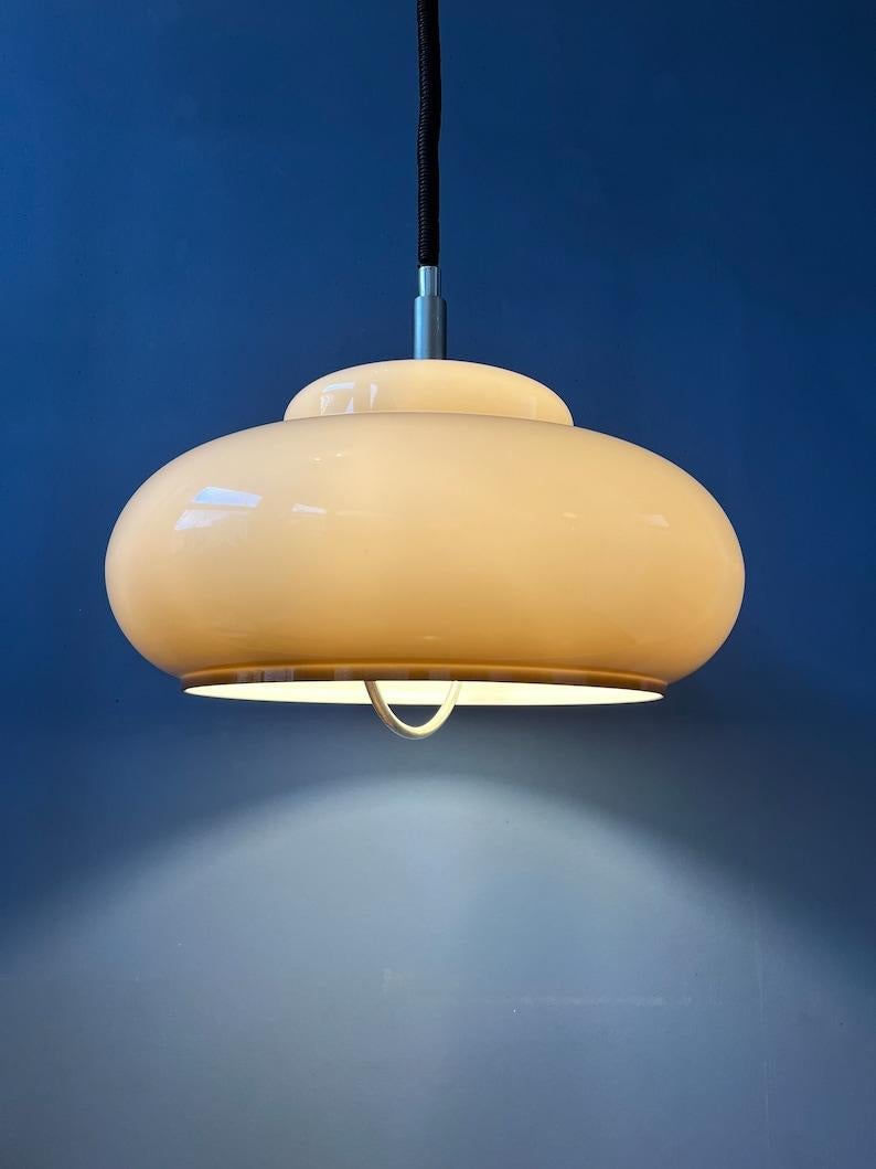 A mid century space age pendant lamp with a beige, acrylic glass UFO mushroom shade. The height of the lamp can be adjusted with the rise-and-fall system. The lamp requires one E26/27 lightbulb.

Additional information:
Materials: Metal,