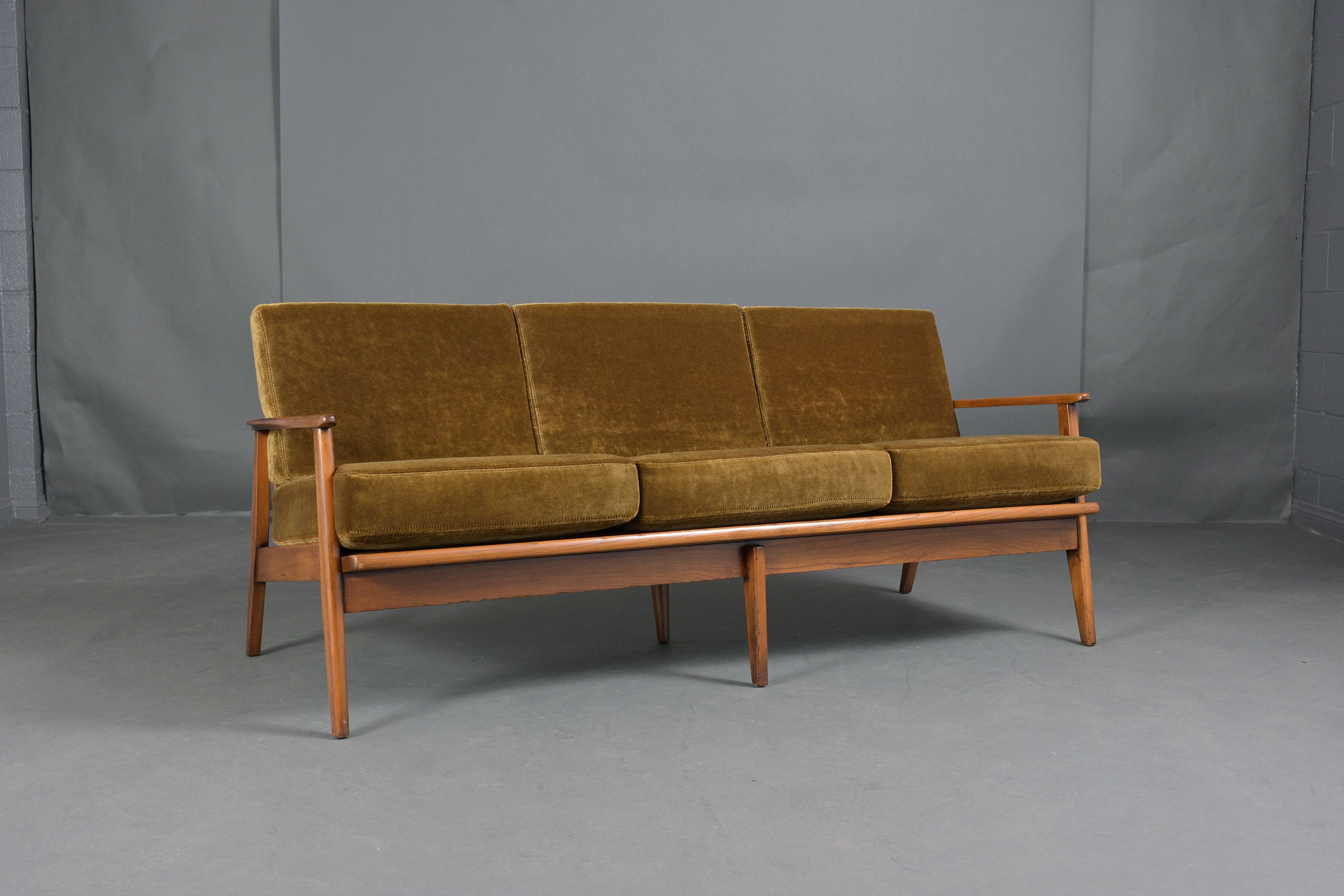 An extraordinary mid-century modern sofa hand-crafted out of solid wood frame with a rich dark walnut color stain with a lacquered finish and is professionally restored by our craftsmen team. This fabulous sofa features sculpted slatted backrests,