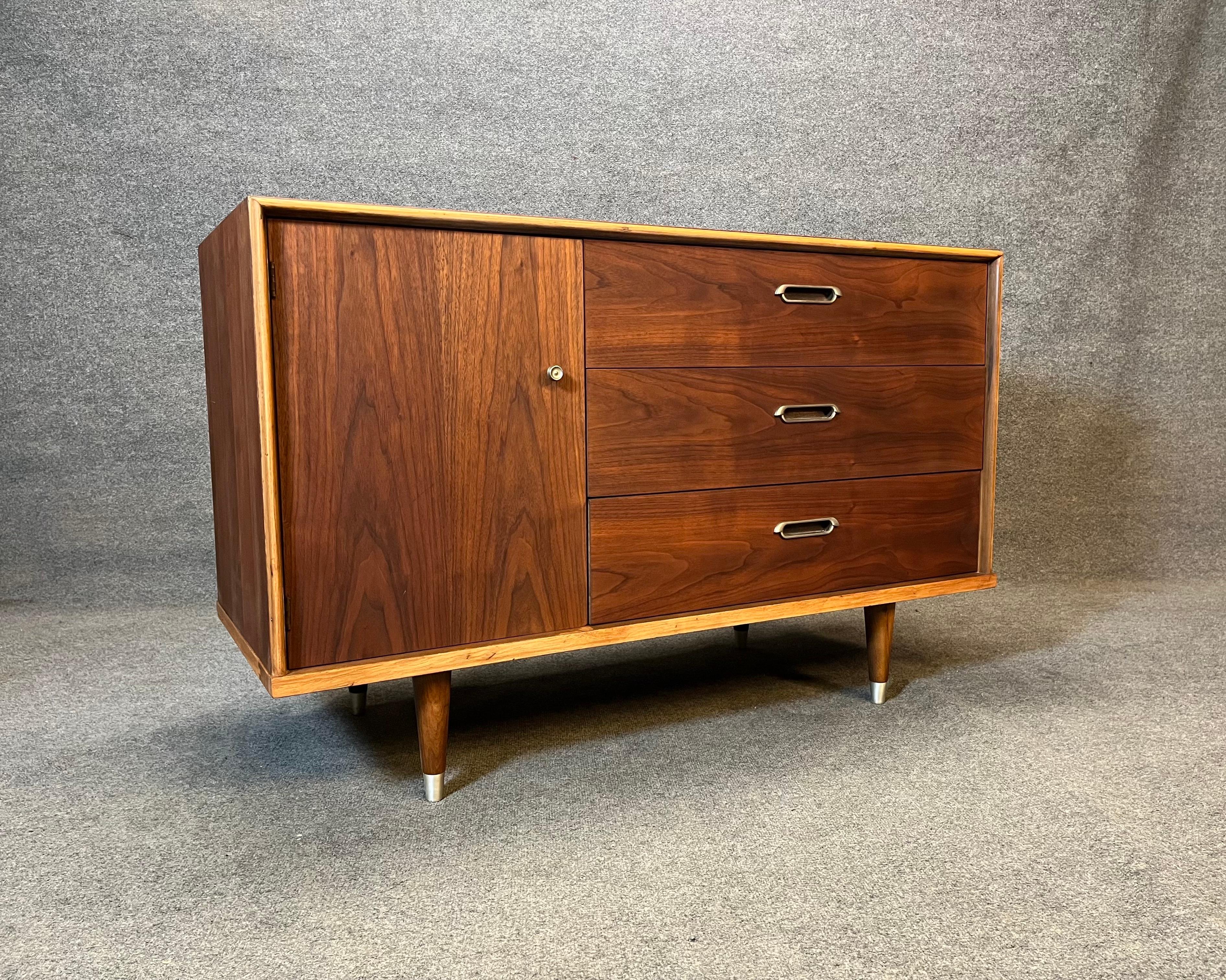 For sale is a vintage credenza by BP John circa 1963 in walnut. Credenza features three drawers and one cabinet. Piece has been completely refinished, hardware has been polished. This piece would make a great entryway piece, small record cabinet or