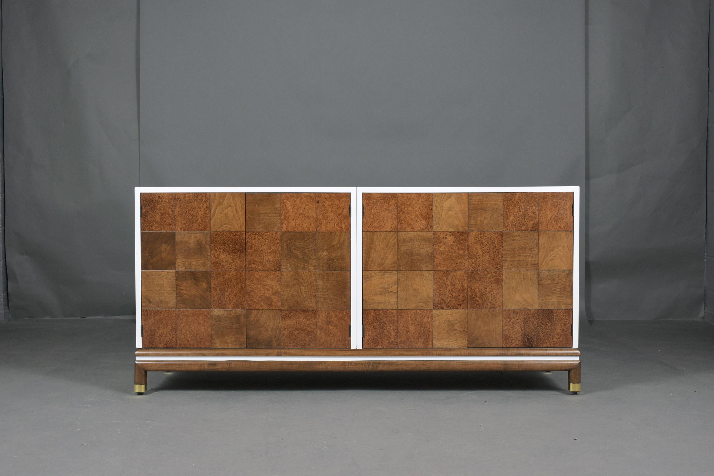An extraordinary mid-century executive cabinet crafted out of walnut in great condition and professionally restored by our team of expert craftsmen. This credenza has been newly finished in walnut and white color combination with the lacquered