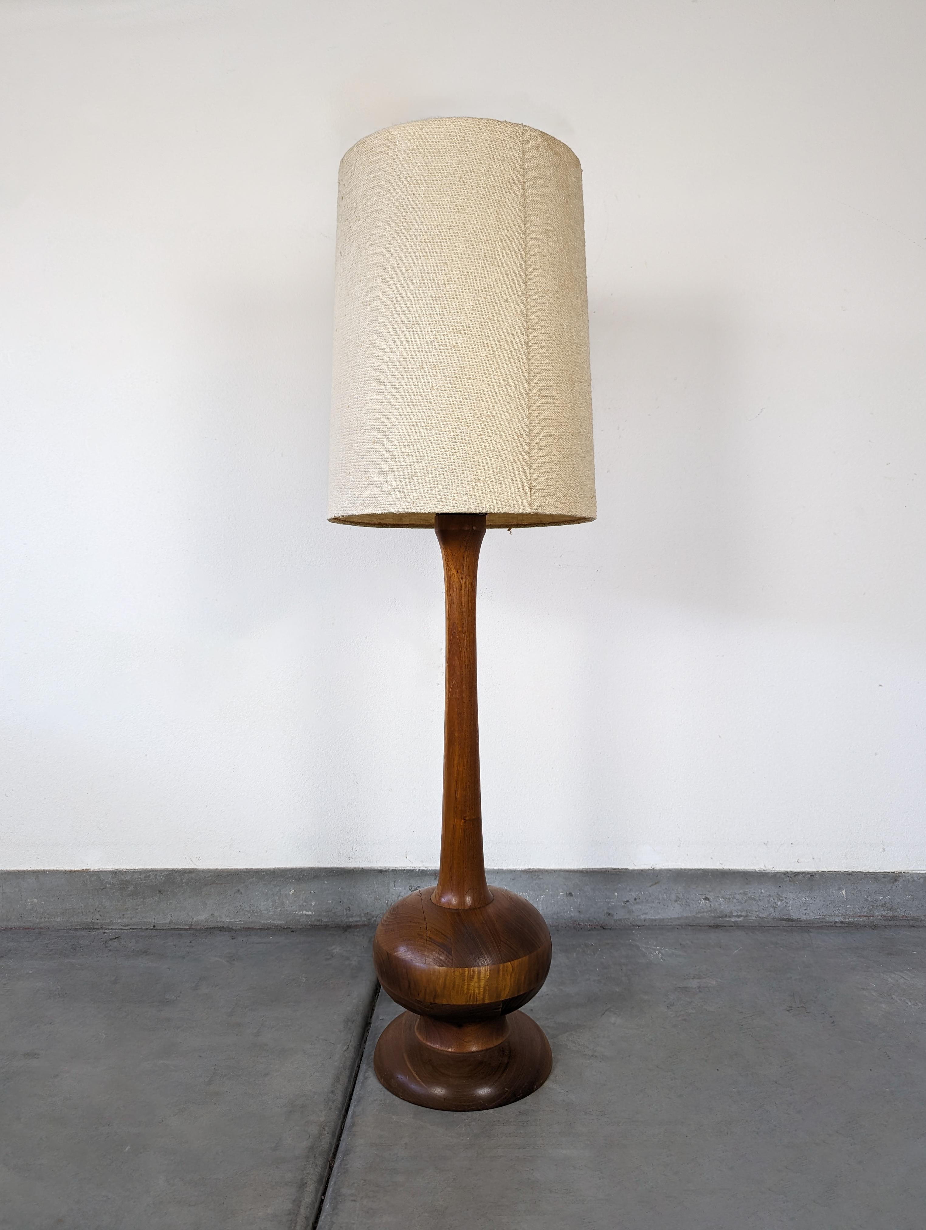 Step back in time with this stunning Mid-Century Modern floor lamp. Crafted from solid wood and featuring a beautiful walnut finish, this piece is a testament to the distinctive style and quality craftsmanship of the mid-20th century. 

The lamp
