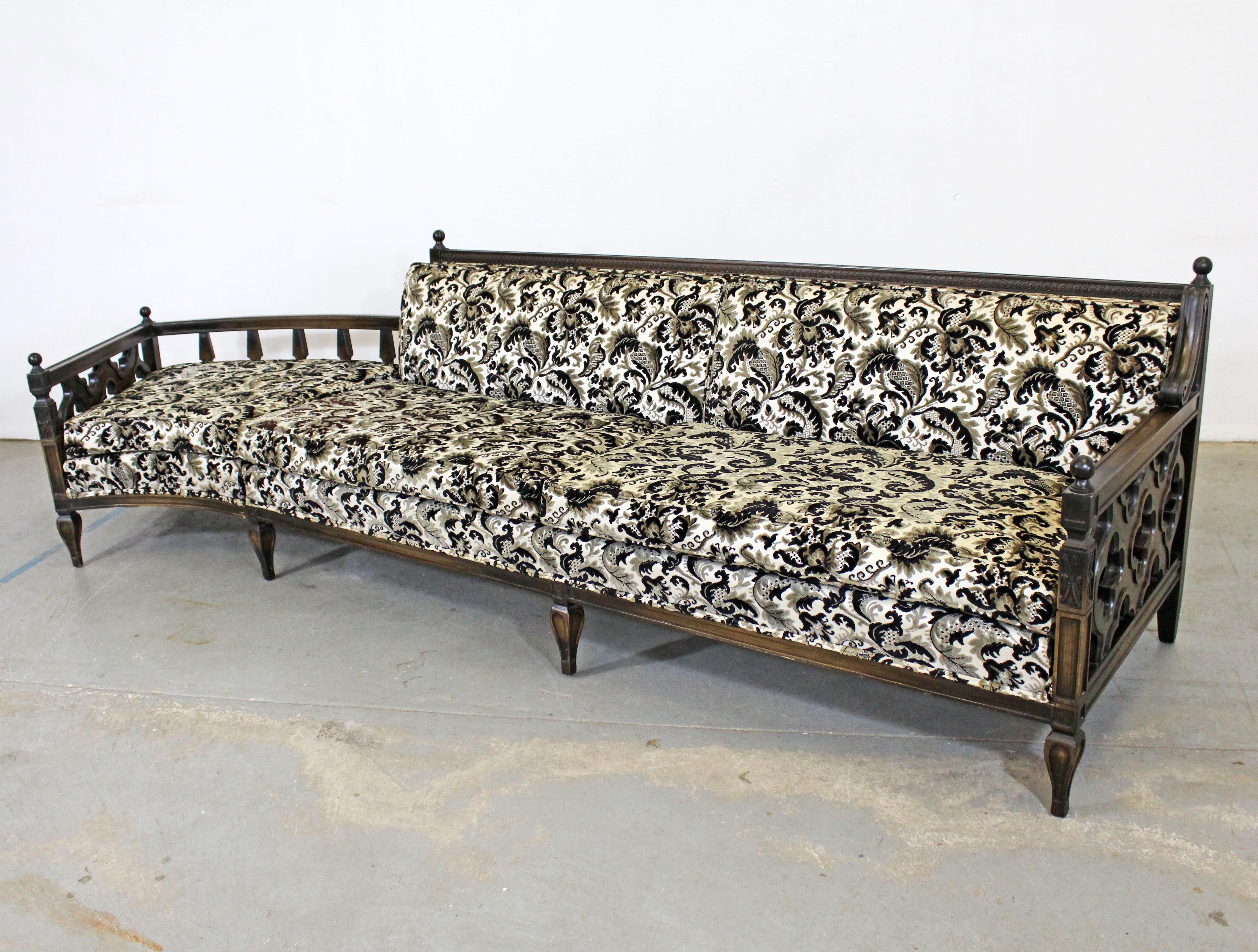 Offered is a vintage mid century sectional sofa with a unique wood frame and textured floral upholstery. Features a Mediterranean flair and a detachable ottoman/chaise. It is in good condition for its age (circa 1970) with some surface