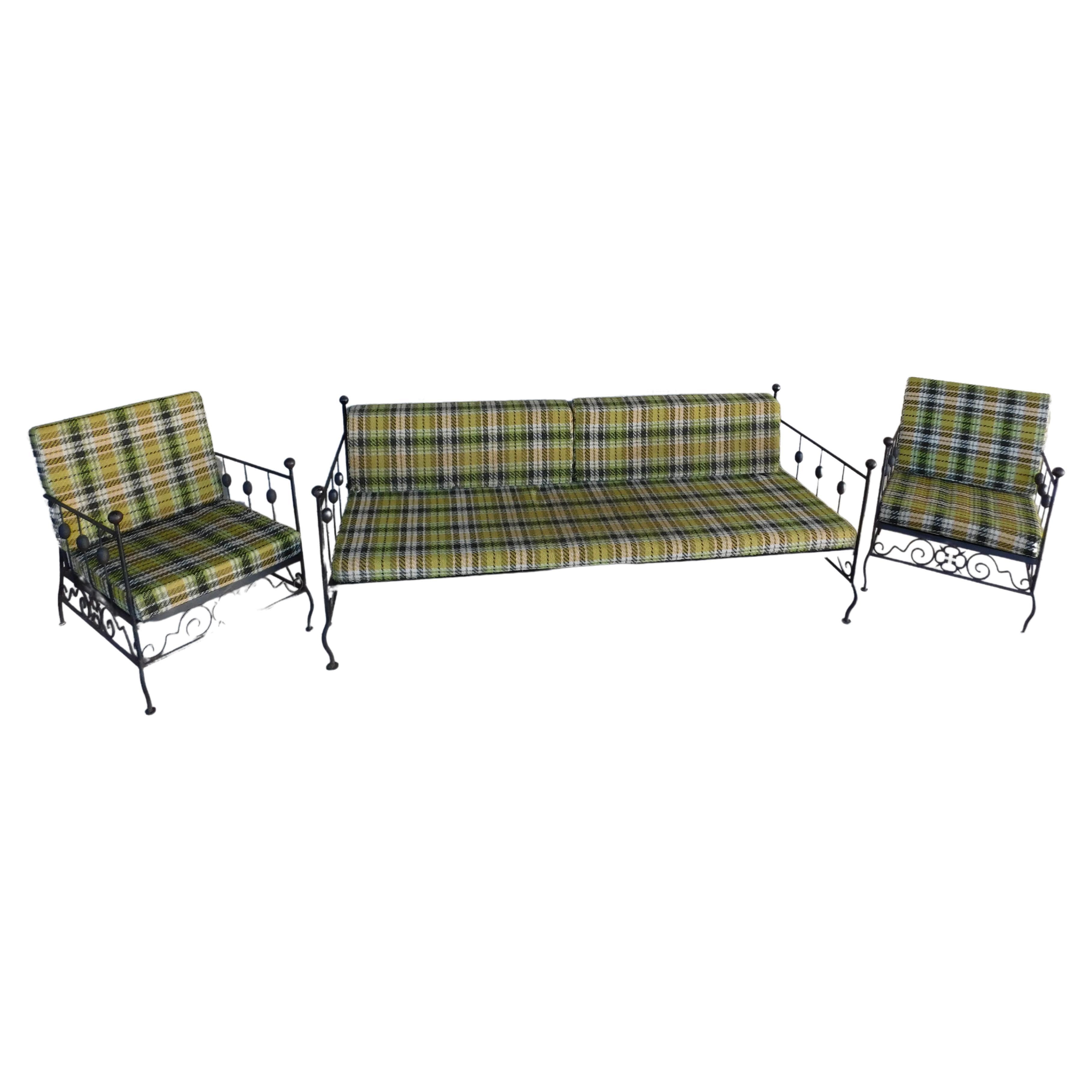 Vintage wrought iron 3 piece set attributed to Authur Umanuff. Unique Cattail Modern design sides, Hairpin style backing, with a Spanish clover motif along the lower front and side rails. Original vintage plaid upholstered cushions. Comfortable club