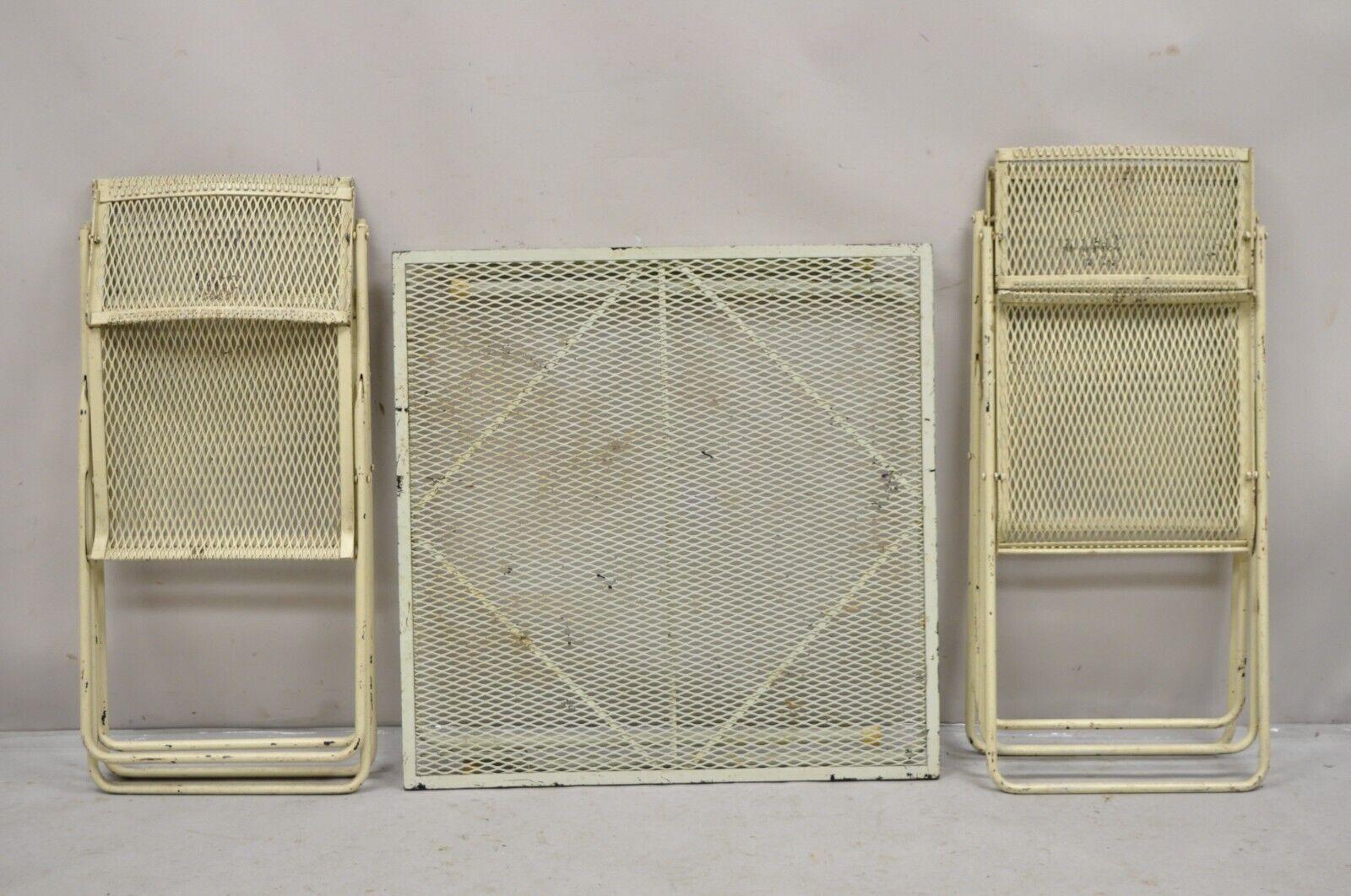 Vintage Mid Century Wrought Iron Industrial Folding Card Game Table Set 5 Pc Set. Item features 4 folding chairs with pivoting backs and one folding table, iron metal mesh frames, folding design, beige painted finish, very unique vintage set. Circa