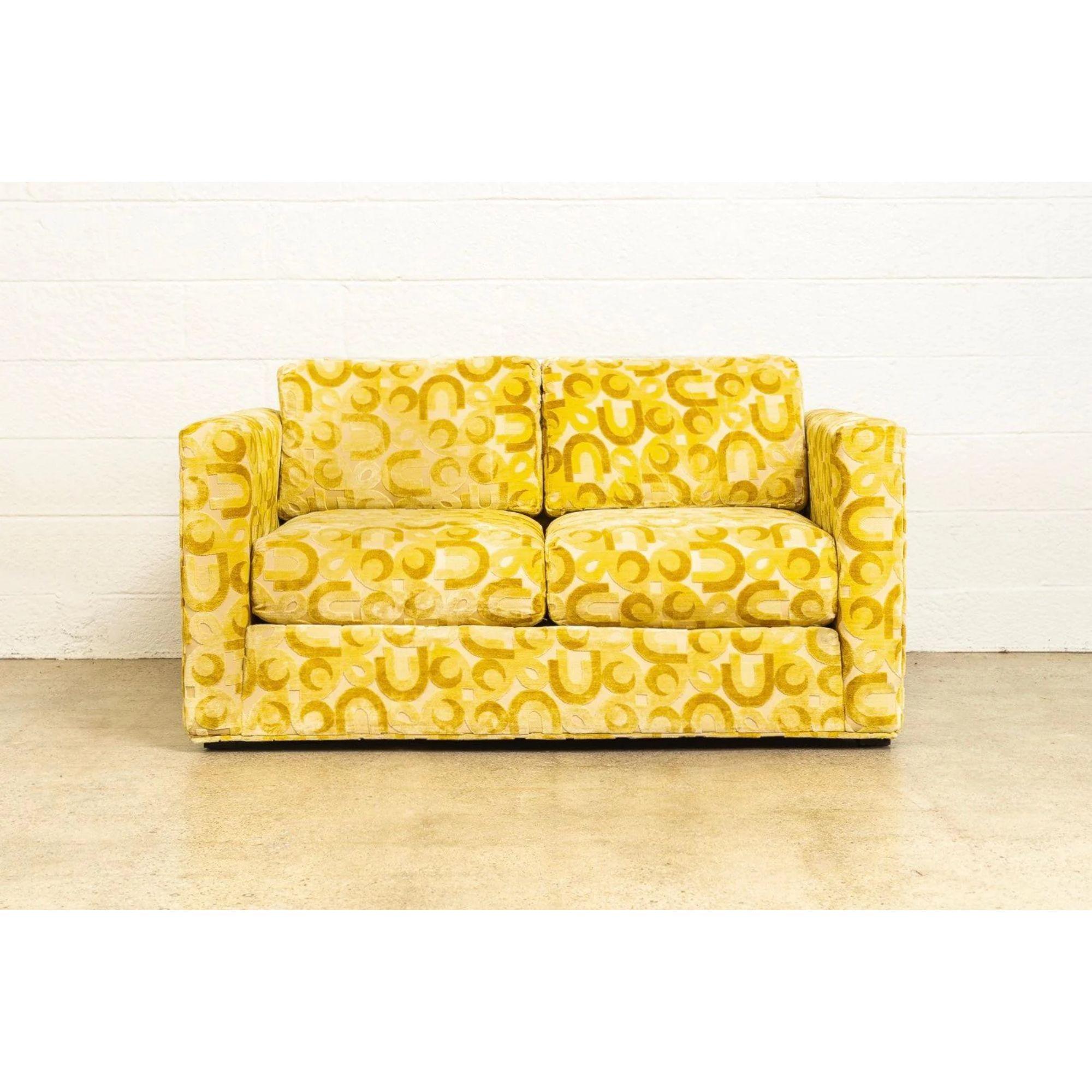 This vintage mid century modern loveseat made by Sawyers Furniture Company is circa 1970. With fabulous mid century styling, this two-seat loveseat has a clean, boxy shape and is upholstered in an incredible mod fabric featuring U-shapes and circles