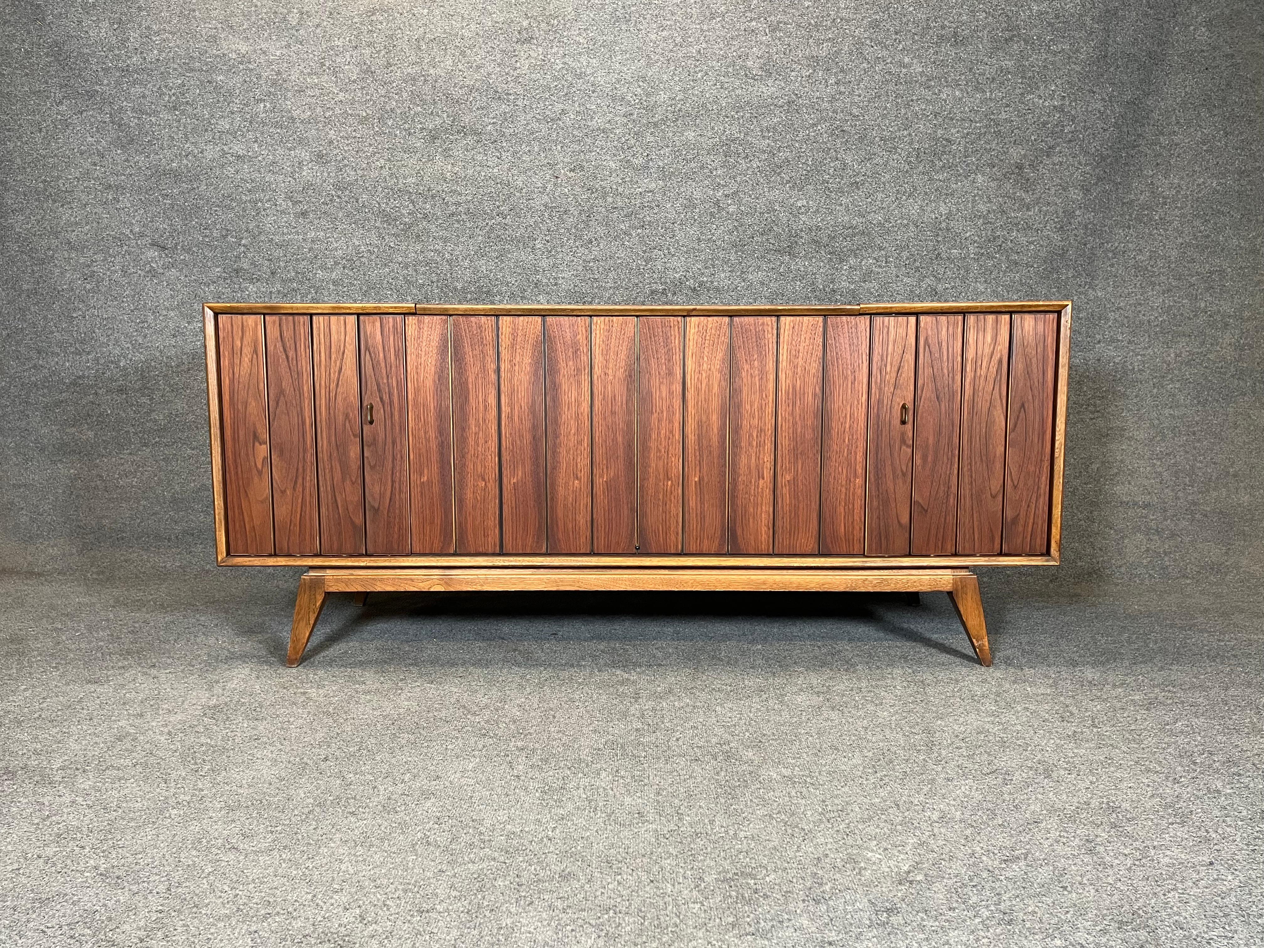 Here is a very sought after Mid century Zenith stereo console. Model Y960. The top, sides and front have been refinished. Made of walnut with a sculptural front. Louvered doors for the speakers. No rips or tears in the speaker cloth. The radio works