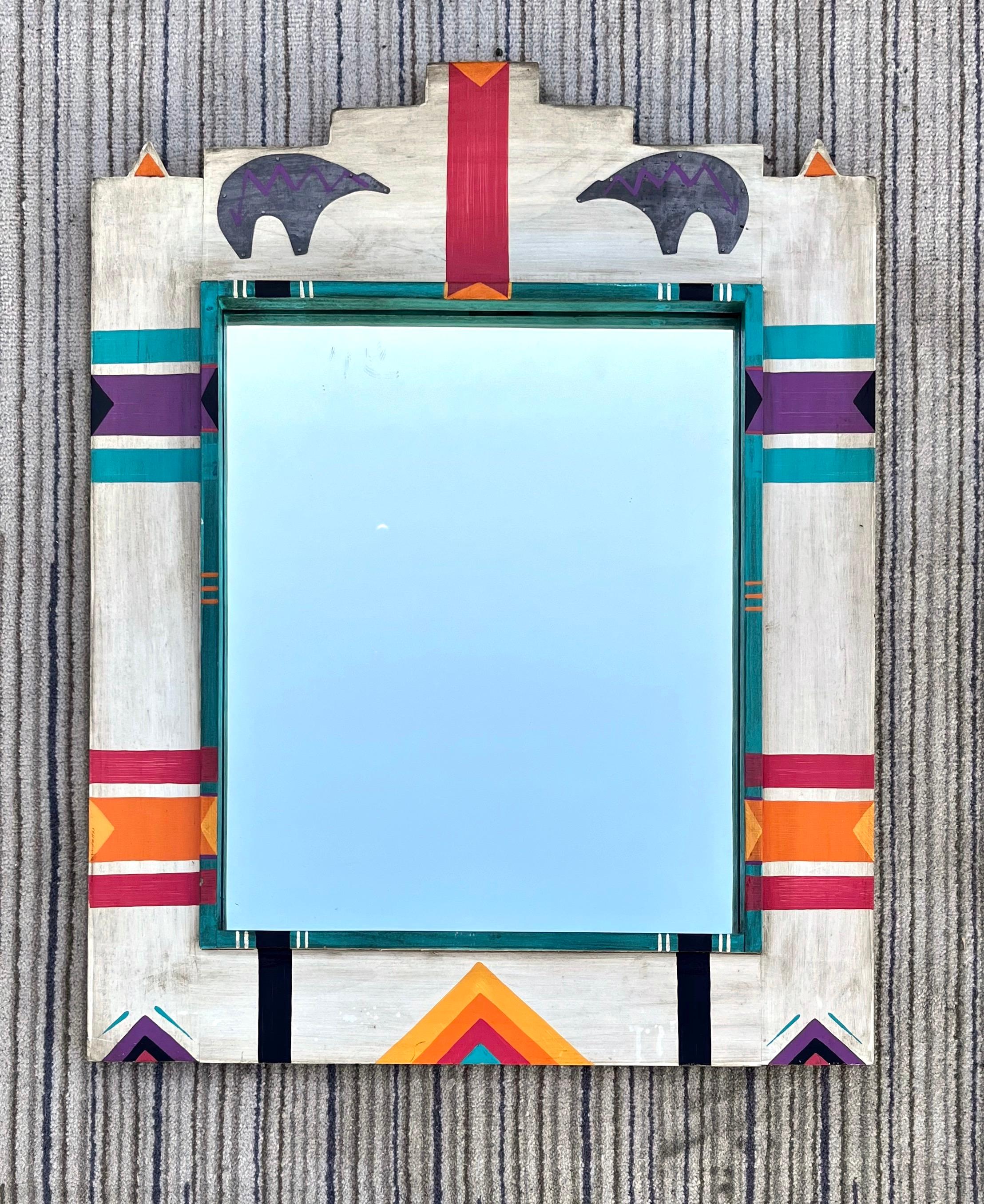 Vintage mid size native American art inspired wall mirror. circa 1980s
Features an off white hand painted solid wood frame with two galvanized metal sheet bear appliqués. 
In excellent original condition, with minor signs of wear and age. Please