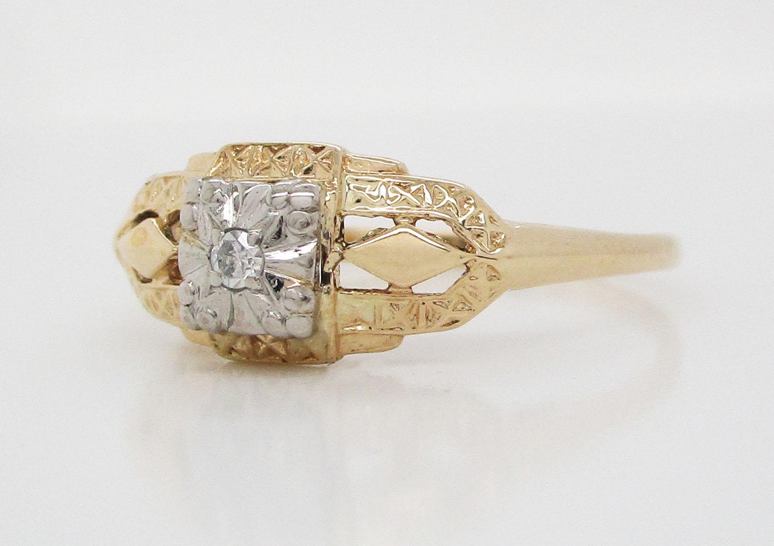 This is a beautiful mid-century ring in 14k white and yellow gold featuring a great dimensional design and a gorgeous center diamond! The design of the ring is unique and features two tones of gold and an excellent architectural look. The shoulders