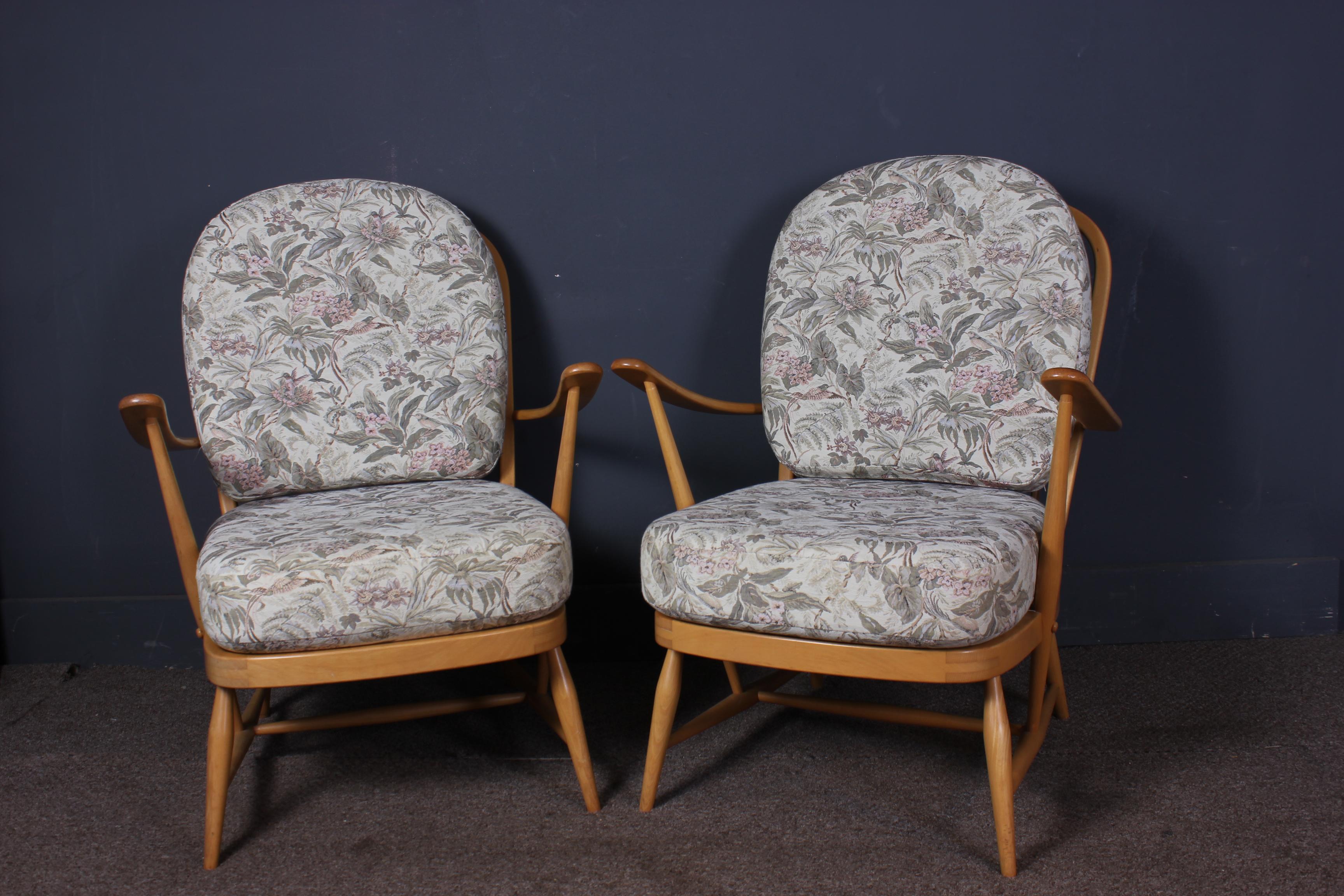 A pair of beautiful blonde Ercol 203 armchairs. These classic chairs have floral pattern fabric cushions and are in beautiful condition with the fabric being very clean with no rips or tears also the webbing is in as new condition on both chairs.
