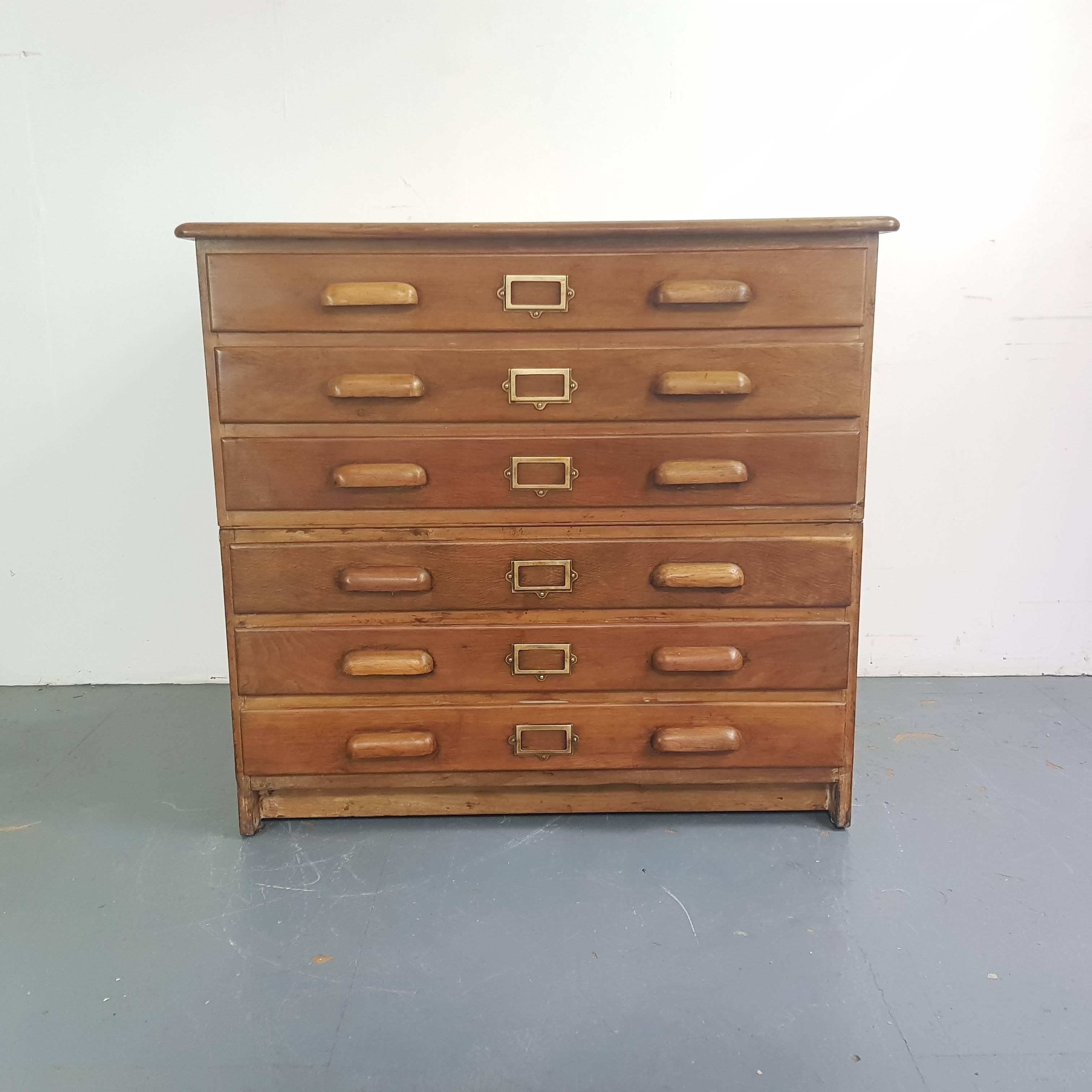 Lovely oak six-drawer midcentury plan chest with wooden handles and brass label inserts.

The plan chest has six solid wooden drawers and panelled sides.

Approximate dimensions: 

Height 87 cm

Width 94 cm

Depth 71 cm

Drawers: 82 cm W