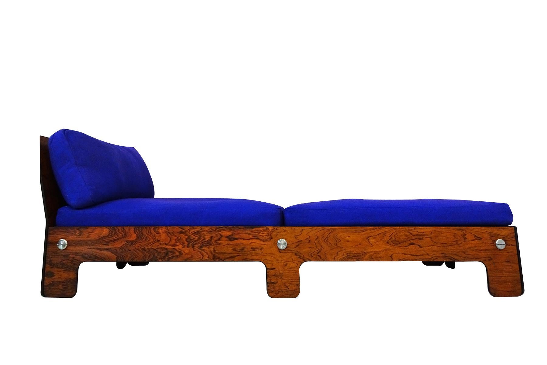 A very rare Midcentury chaise longue or day bed in blue and rosewood.

Very little is known about the designs origins of this beautiful and unusual chaise. The striking design using rosewood veneer complimented by large polished steel screw/bolts