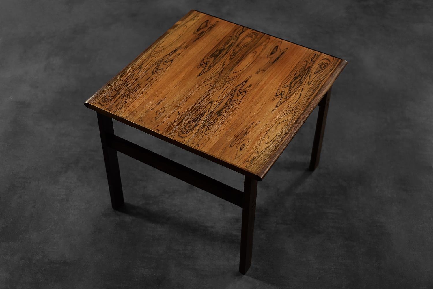 Cette table basse carrée classique de la série Capella a été conçue par Illum Wikkelsø pour la manufacture danoise Niels Eilersen dans les années 1960. Il est fabriqué en bois de rose noble de haute qualité. Cette table basse a une couleur brune