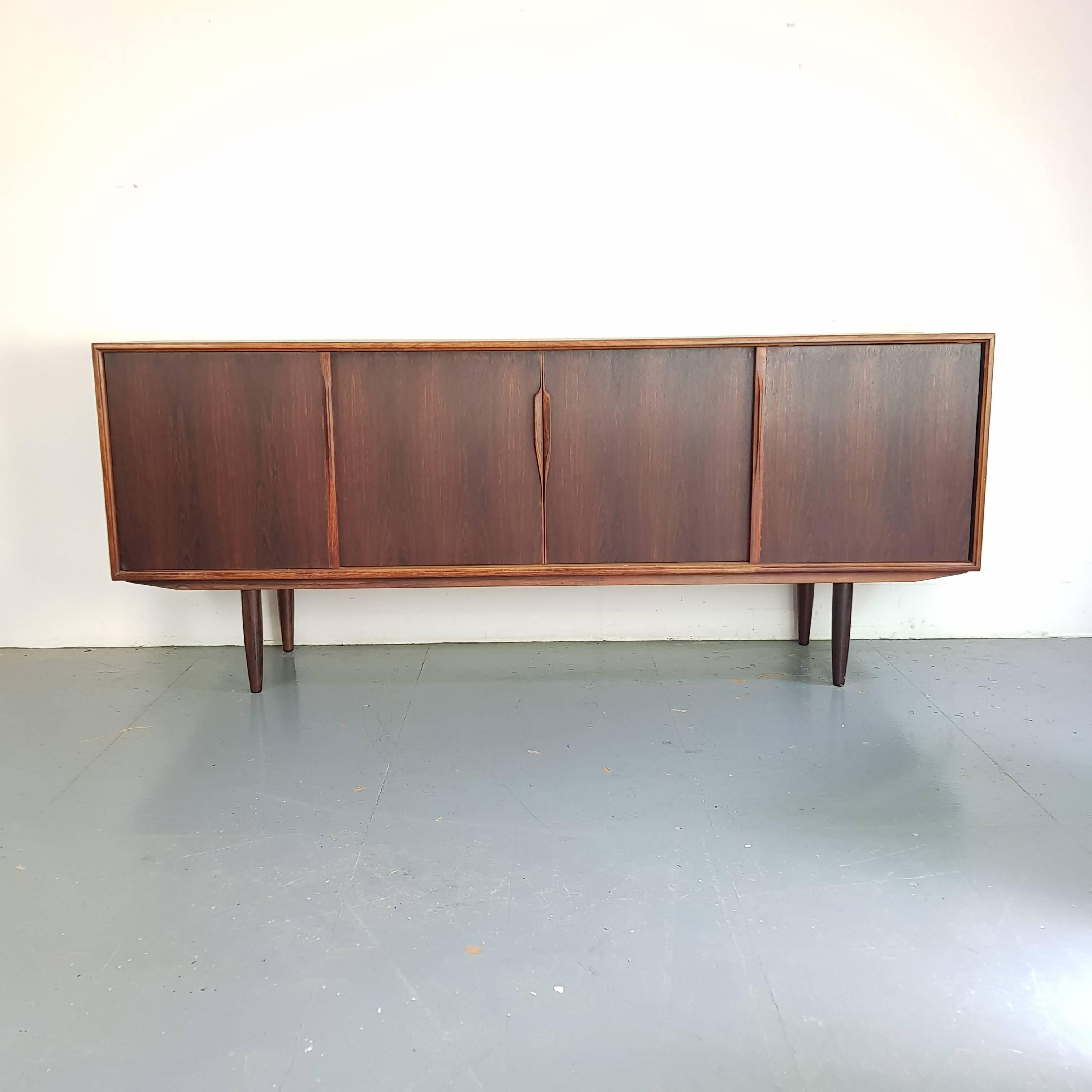 Lovely midcentury Danish sideboard designed by Gunni Omann in rosewood.

Approximate dimensions:

Width: 201cm

Depth: 47cm

Height: 83cm

Drawers: 45cm x 37cm x 5cm
Middle: 93cm x 41cm x 50cm (25cm twice)
Left: 53cm x 41cm x 50cm (25cm