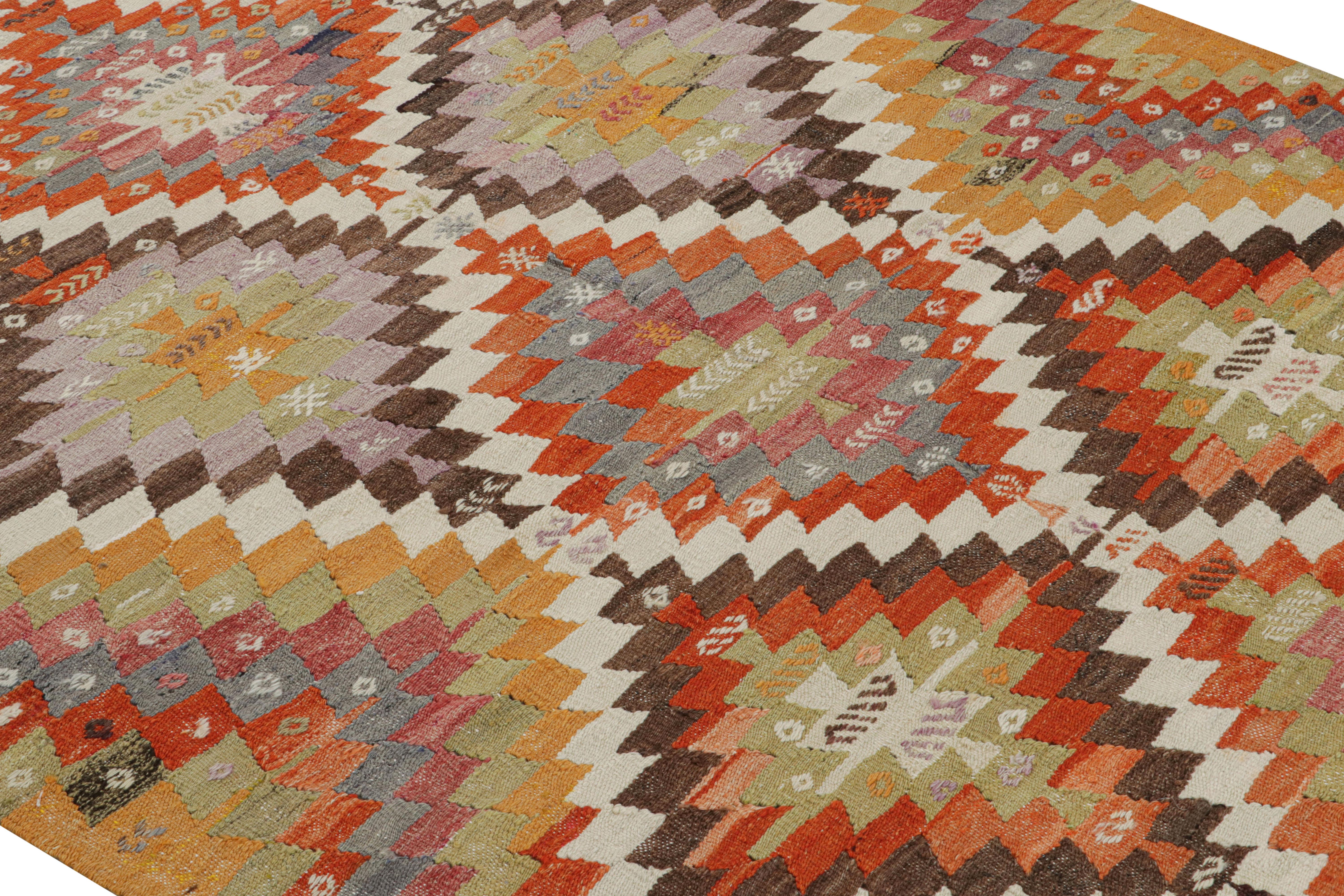 Flat-woven in Turkey originating between 1950-1960, this vintage midcentury tribal Kilim hails from the city of Denizli, and enjoys a lively and playful variation of golden-yellow, orange, green, red, brown, purple, blue and light green hues