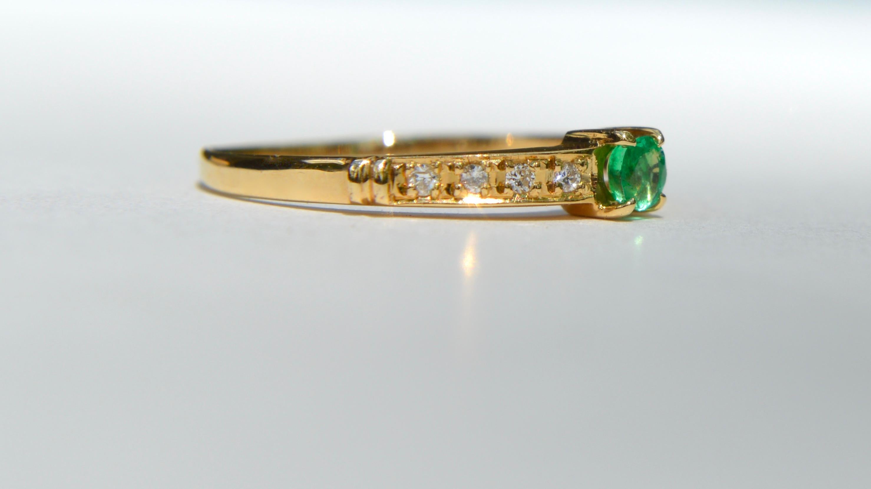 Beautiful vintage midcentury era 1970s .11 carat vintage round cut Colombian emerald 18K yellow gold ring with 8 total .015 carat round cut diamonds (1.5mm diameter each). Emerald measures 3mm, and is a bright saturated Kelly green. The emerald as