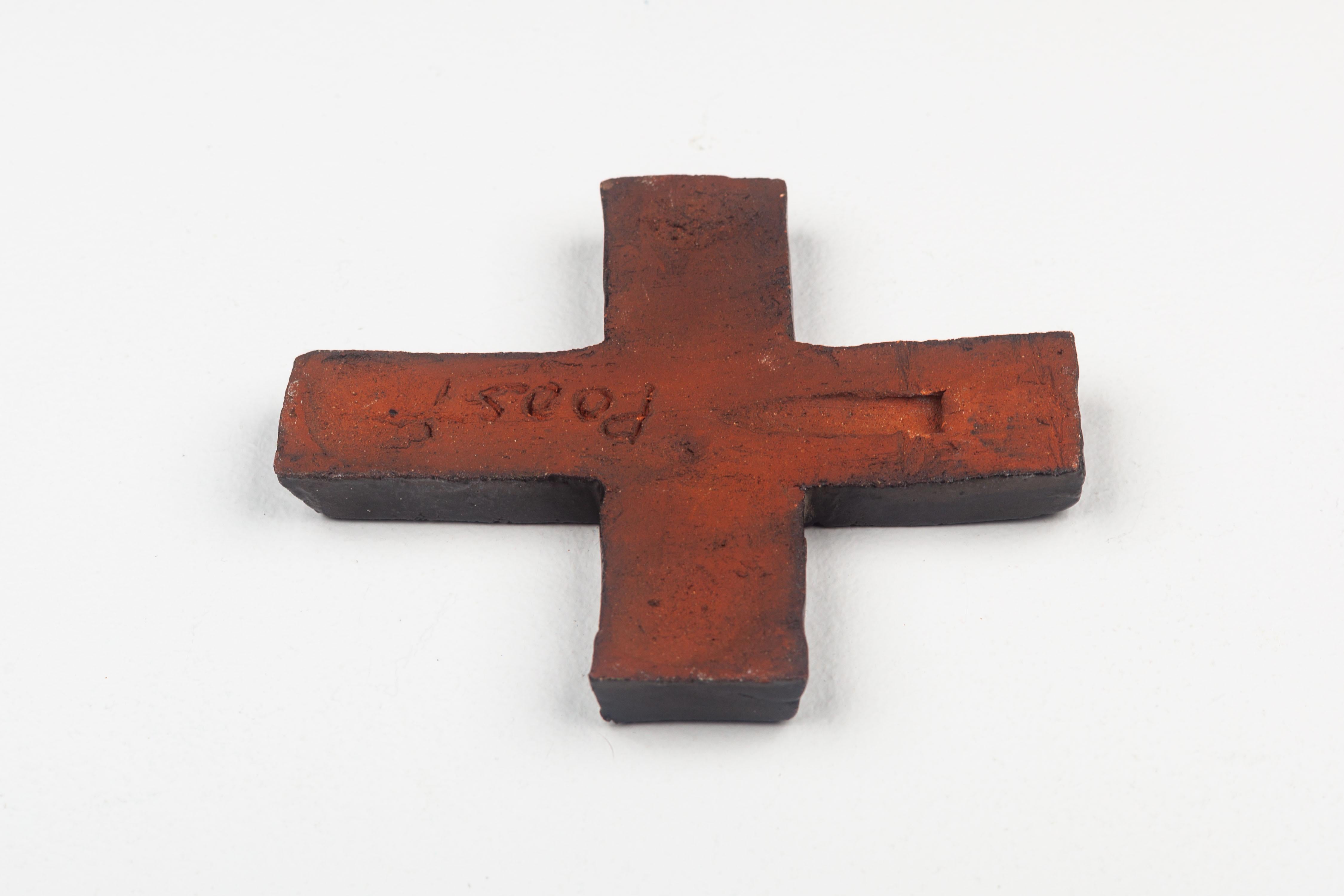 This ceramic crucifix is a quintessential representation of mid-century modern artistry, characterized by its sleek lines and the juxtaposition of muted tones. Handcrafted by a European studio pottery artist, the piece stands out for its textural