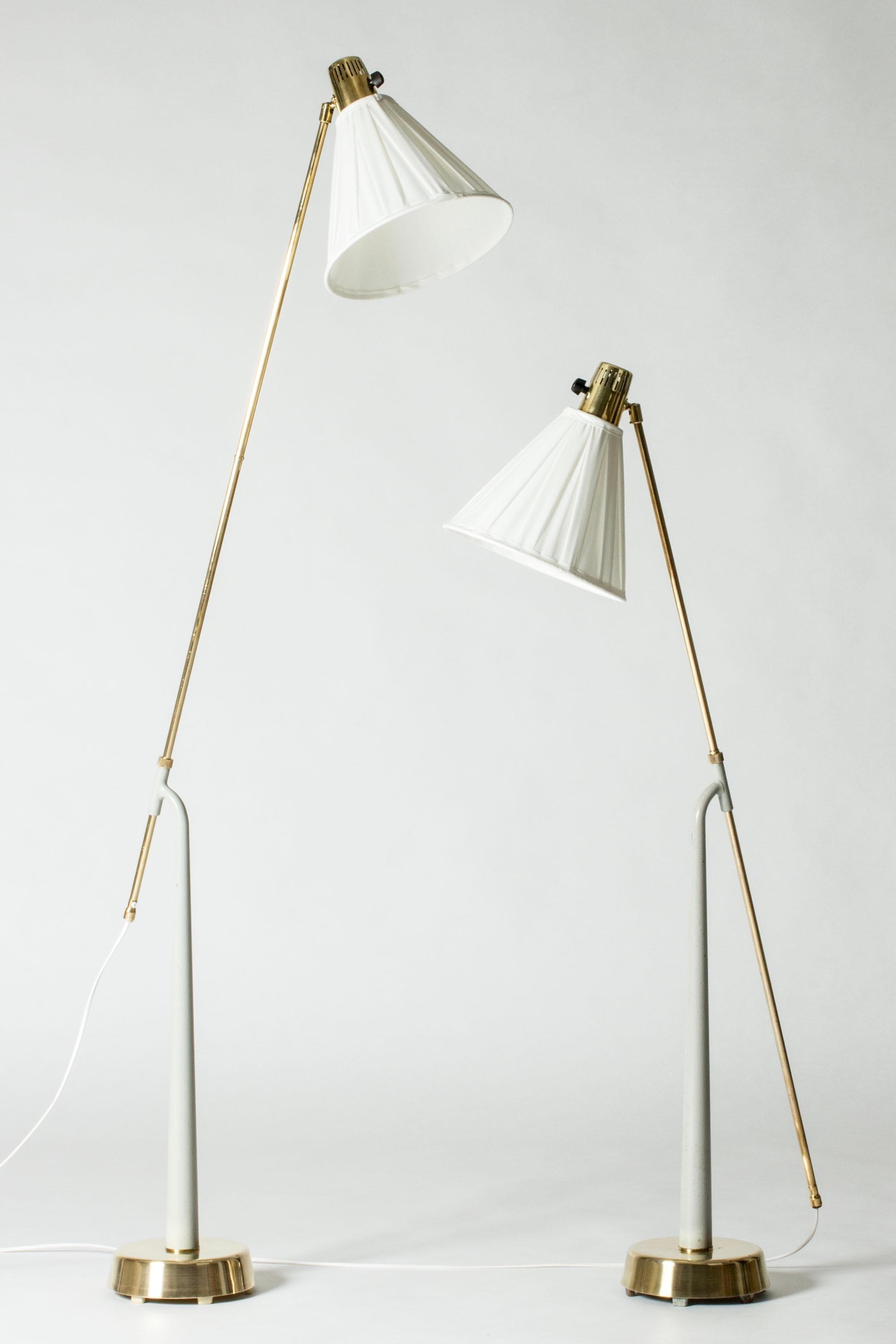 Pair of amazing floor lamps by Hans Bergström, made from brass and light grey lacquered metal. Adjustable height by sliding the brass poles through the holes on the sculpted stems. Cool, well made and elegant.

Height 115-162 cm.

Hans Bergström was
