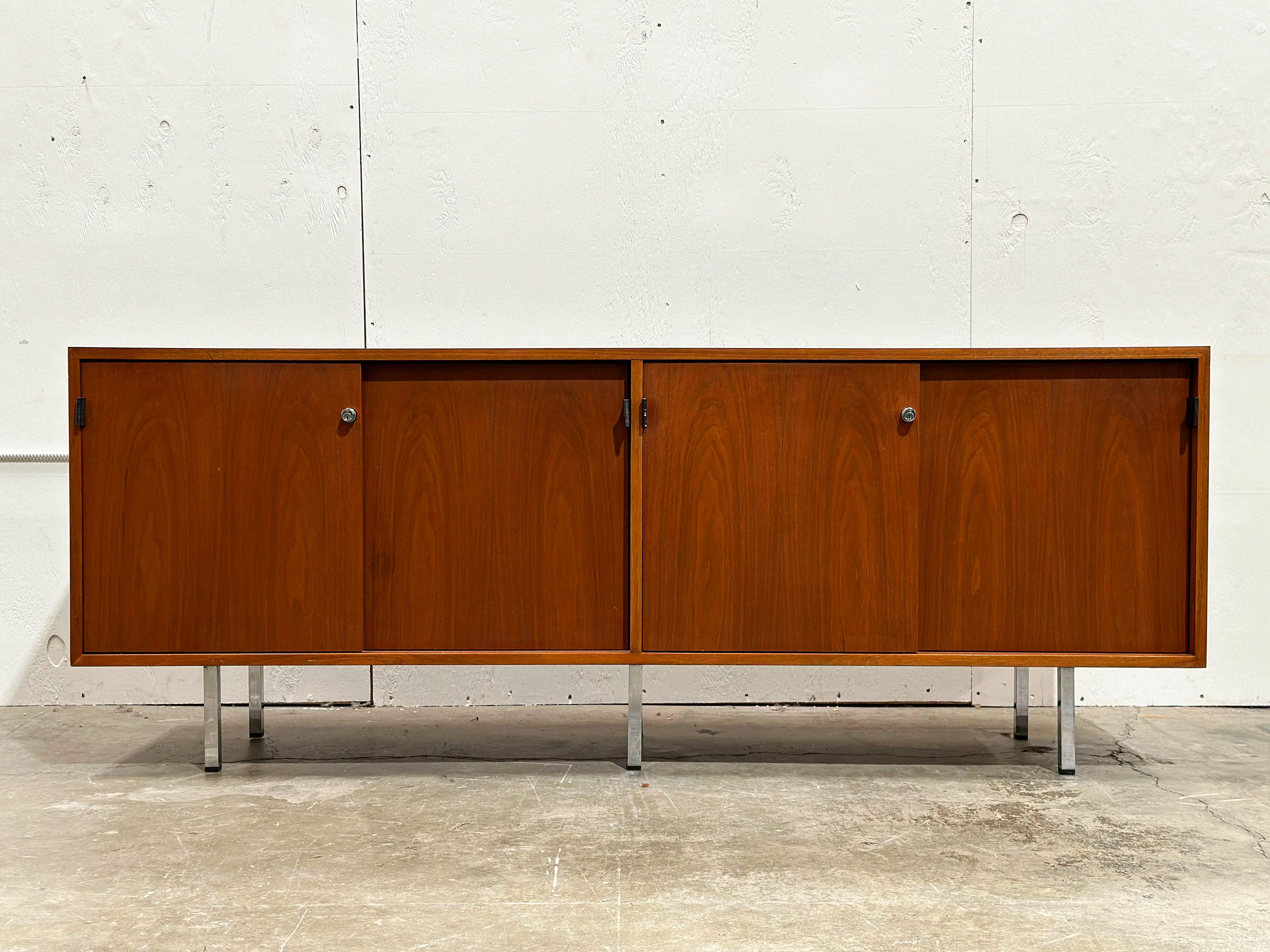 Mid Century Modern credenza by Florence Knoll for Knoll International, circa 1960s.
Walnut case with a walnut tone laminate top, chromed steel legs, black leather pulls and a white oak interior.
Excellent original condition with no flaws of note.