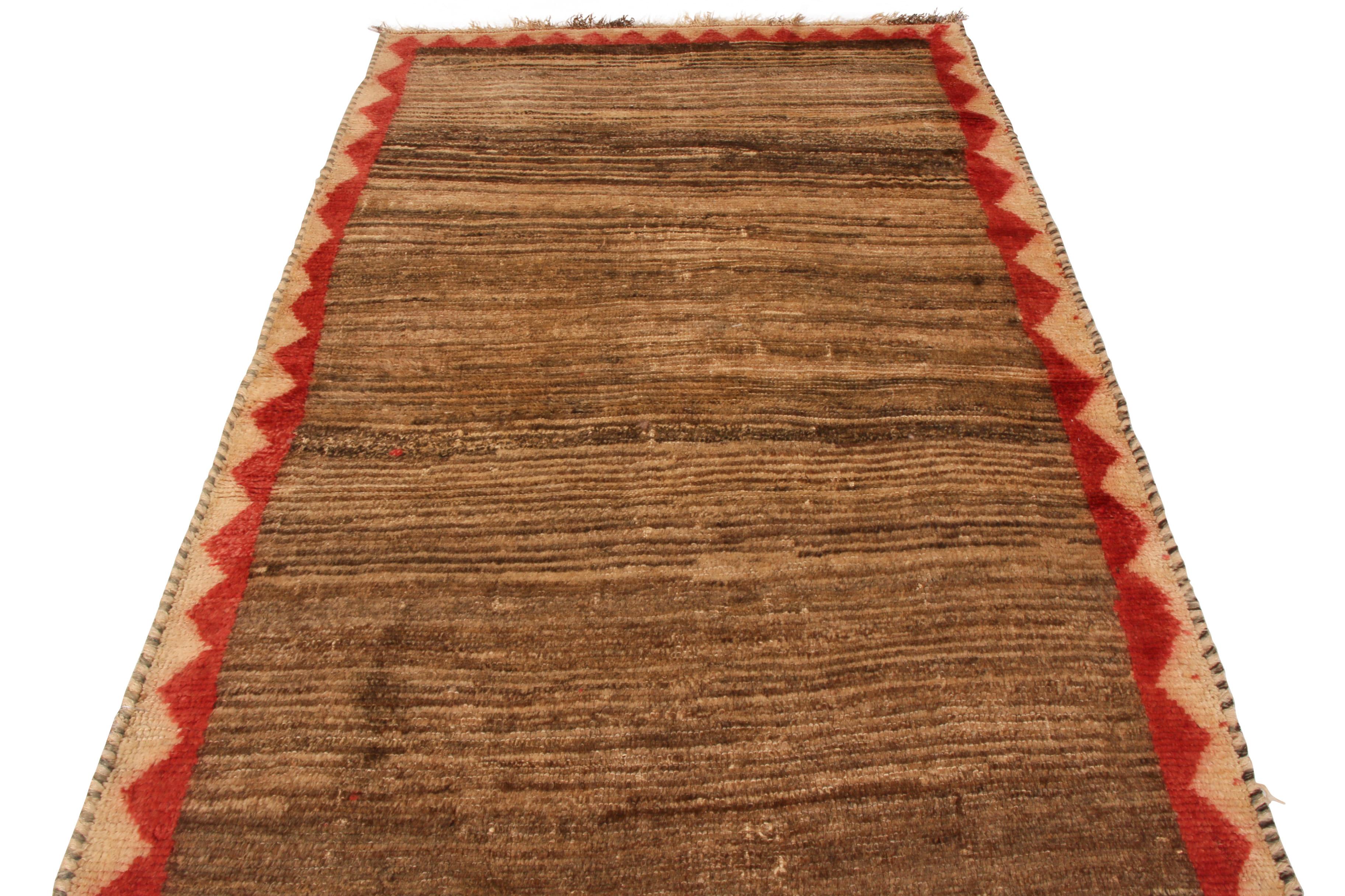 Fabriqué en laine nouée à la main et datant des années 1950-1960, ce tapis persan Gabbeh vintage du milieu du siècle présente un jeu de couleurs unique et transitoire dans le motif du champ entier, créant à la fois un mouvement visuel et une
